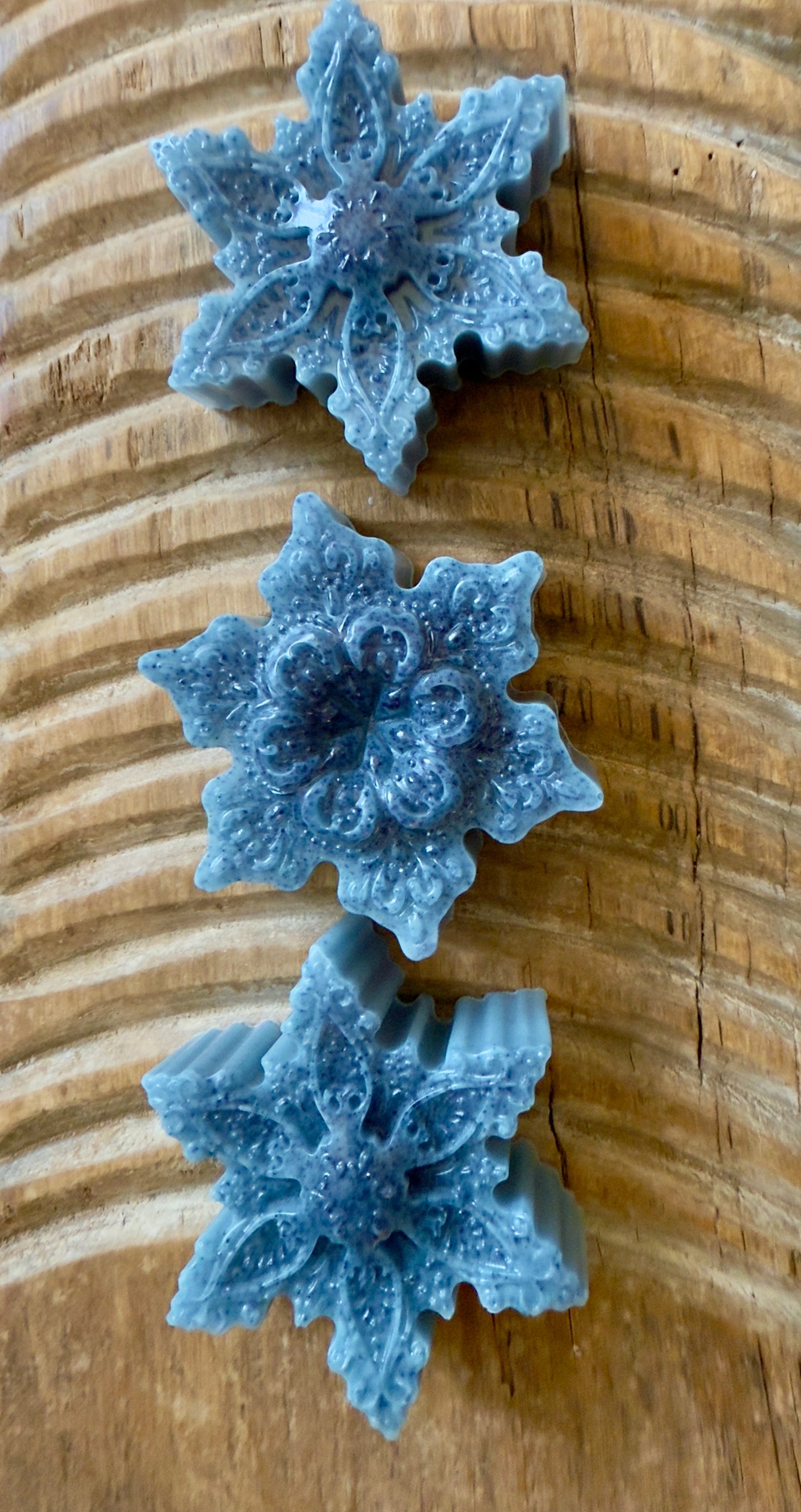 Blue snowflake goat milk soap with speckled detailing, sculpted pattern, and winter finish.