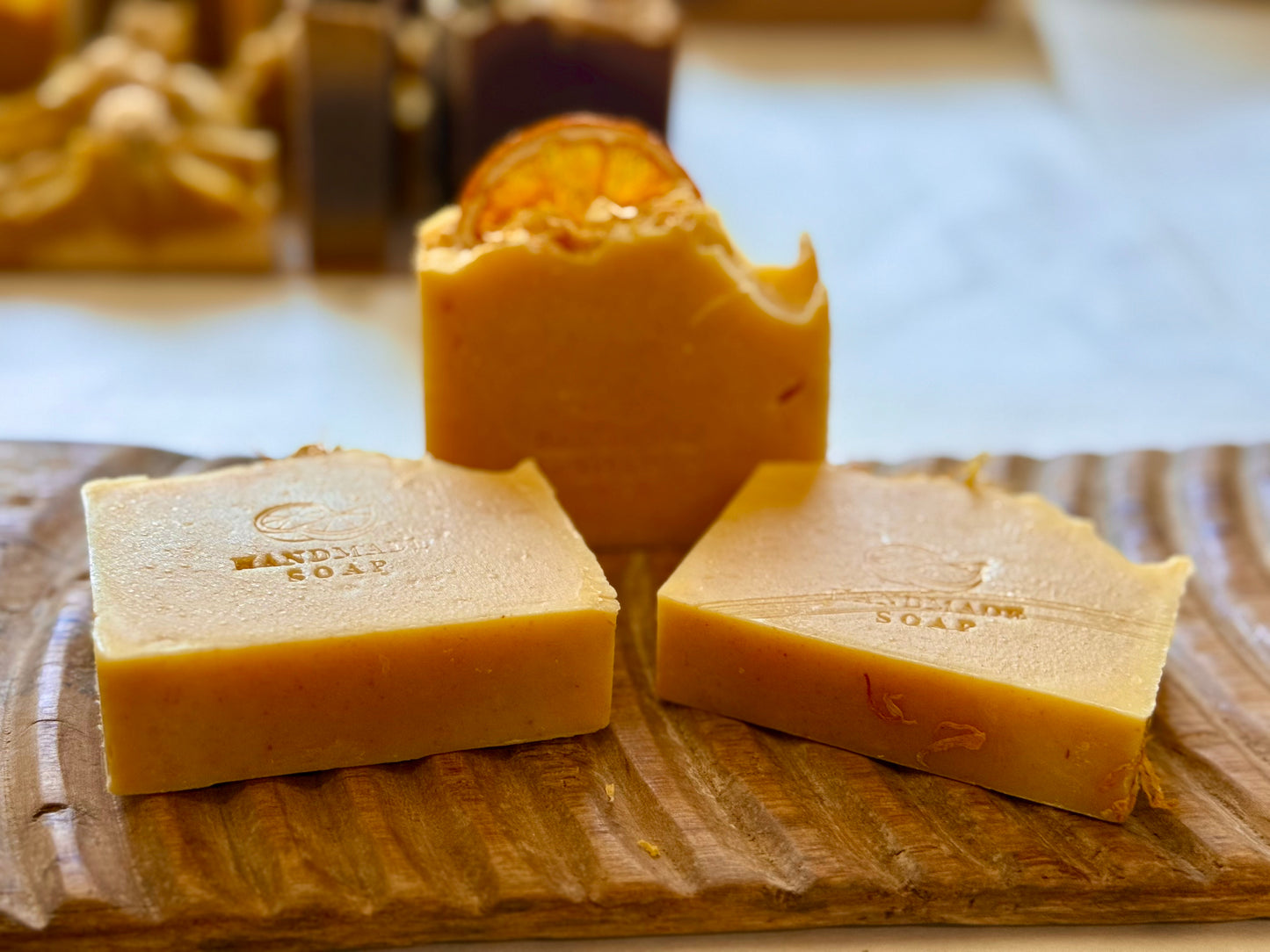 Handcrafted citrus soap with orange peel powder and calendula petals and dried orange slice on top