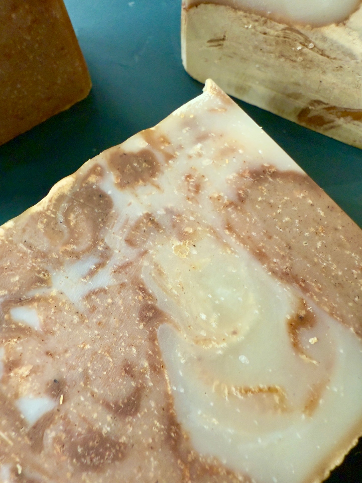 Close-up of a bar of soap with a marbled pattern on a green surface