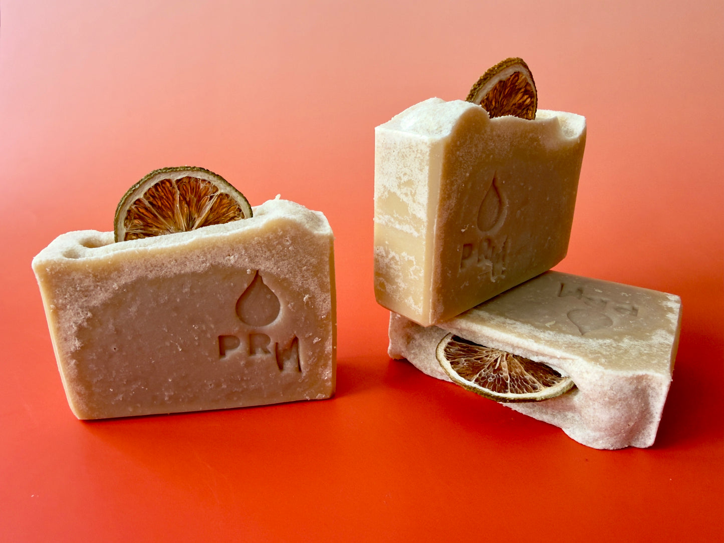 Group of Mint + Grapefruit soap bars stacked and standing, showing smooth faces, light frosting, and lime slice tops