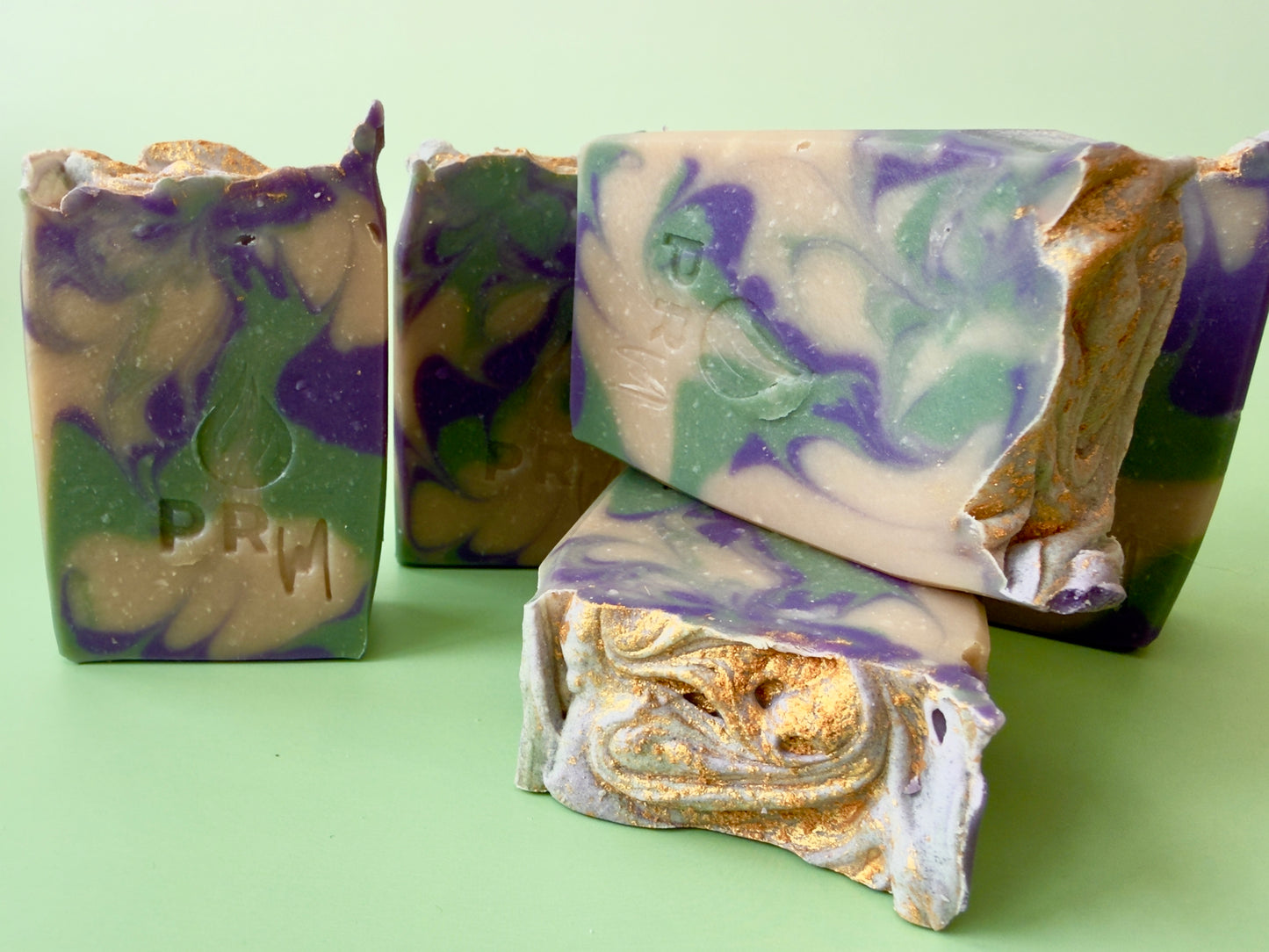Group of Orange Coconut Melon soap bars showing marbled interior, stacked and standing, with gold mica visible along textured tops
