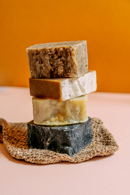 Stacked handmade soap bars in natural tones, illustrating different soap-making methods used in small-batch bar soap.