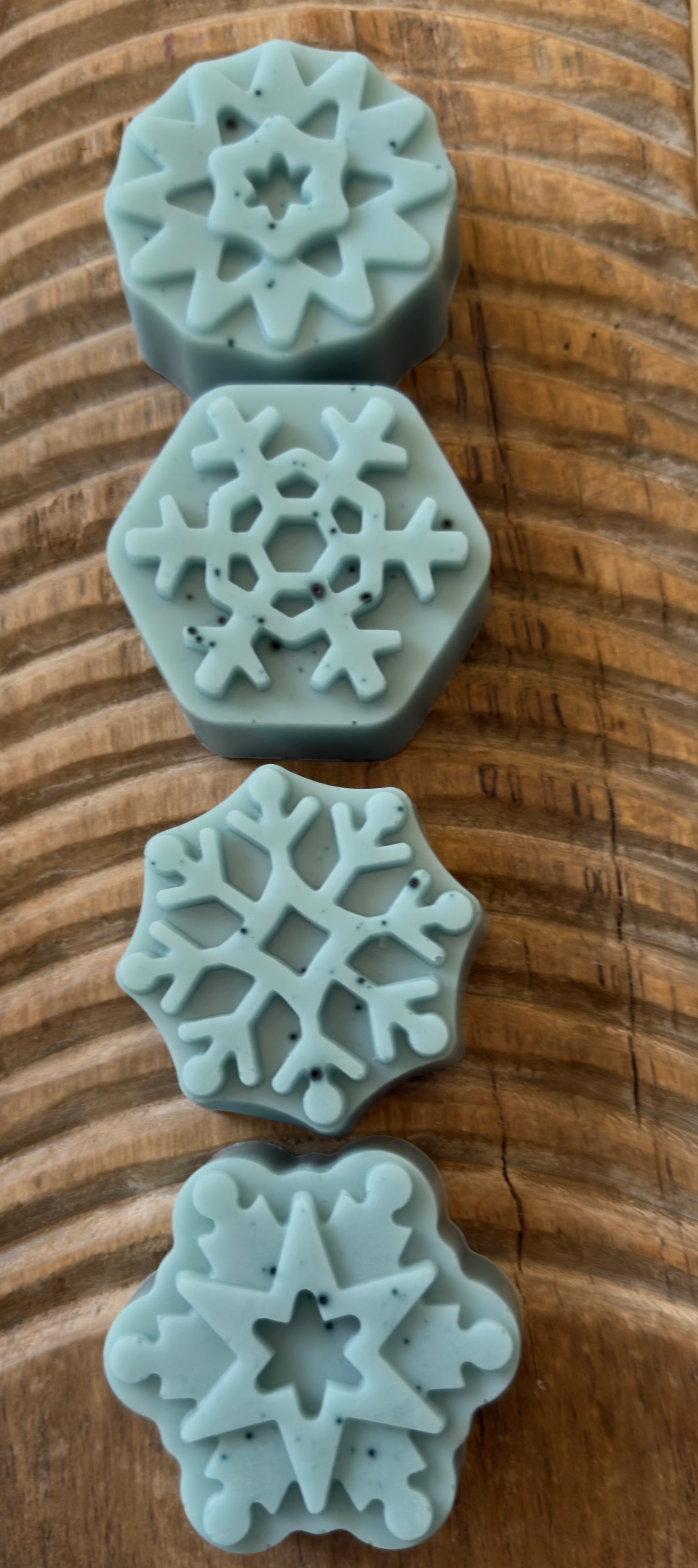 Soft blue goat milk soap pucks and snowflake shapes with natural speckling from butterfly pea powder.