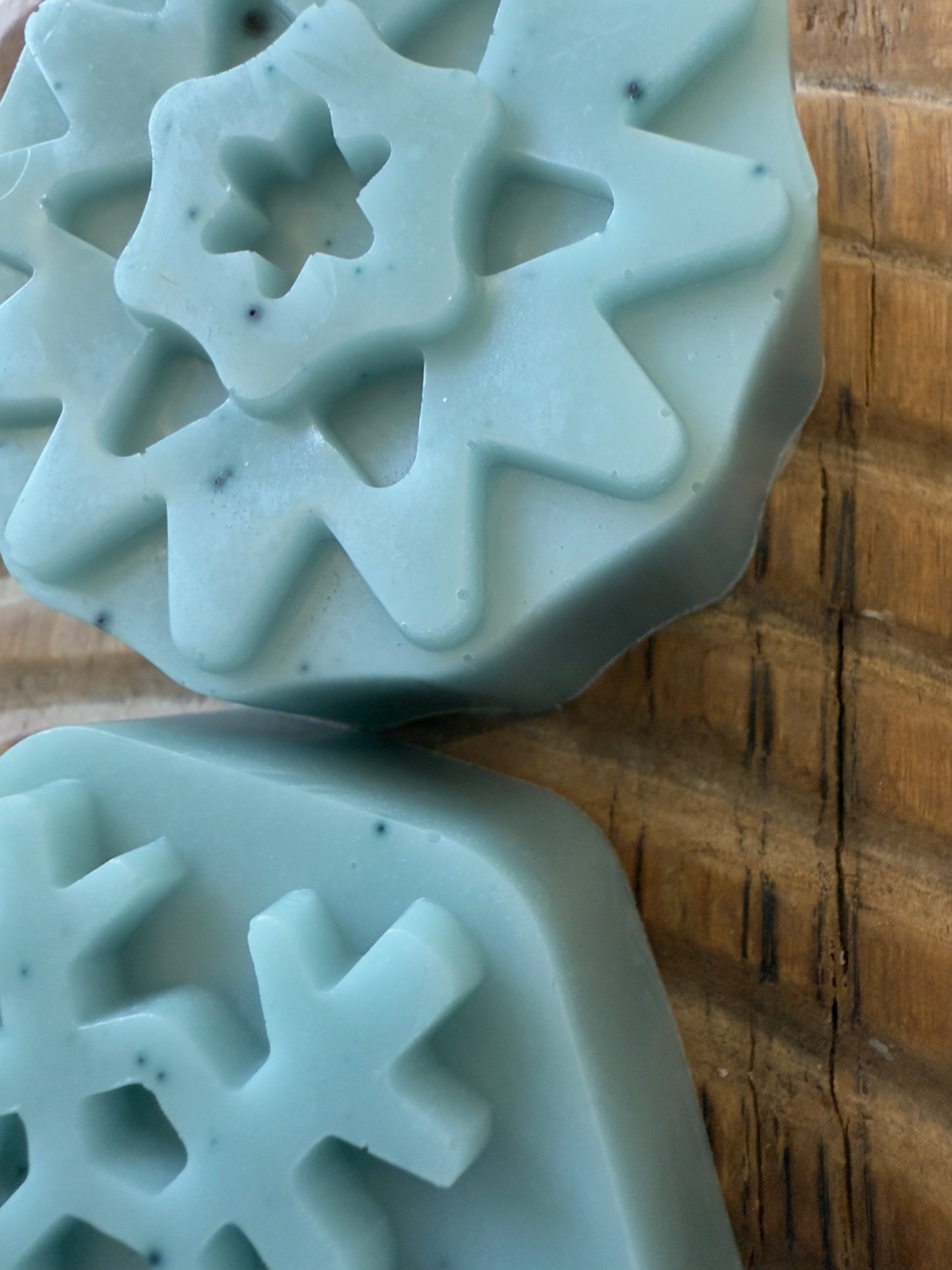 Soft blue goat milk soap pucks and snowflake shapes with natural speckling from butterfly pea powder.