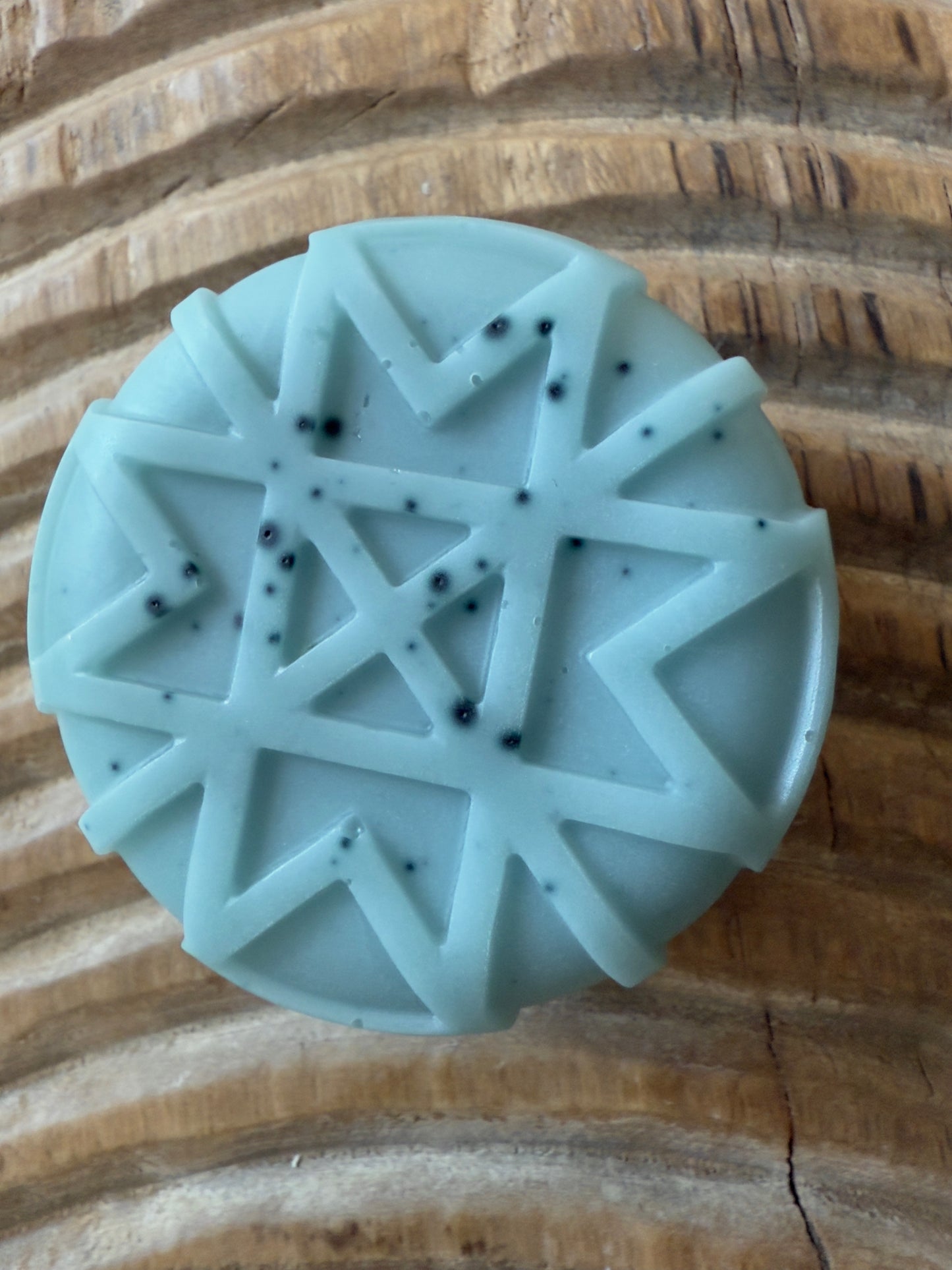 Soft blue goat milk soap pucks and snowflake shapes with natural speckling from butterfly pea powder.