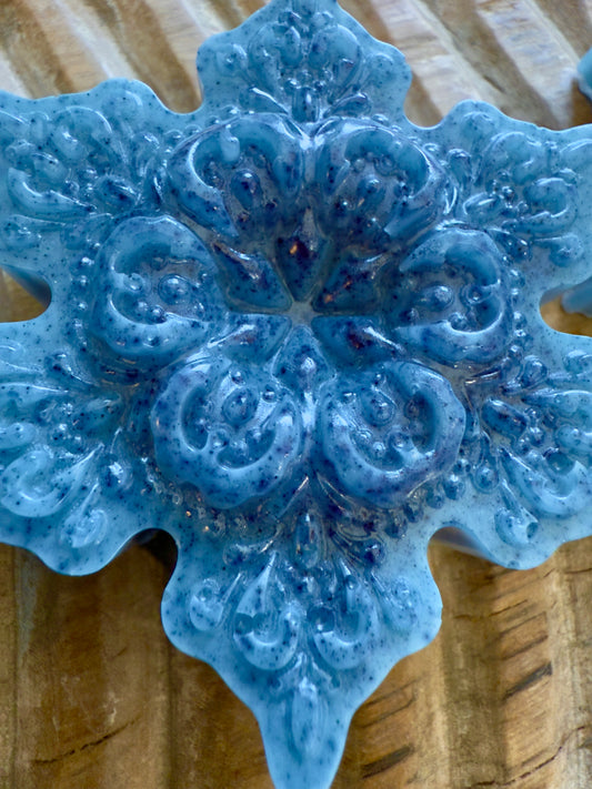 Blue snowflake goat milk soap with speckled detailing, sculpted pattern, and winter finish.