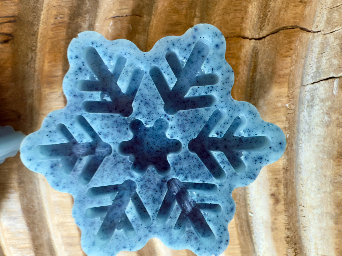 Blue snowflake goat milk soap with speckled detailing, sculpted pattern, and winter finish.