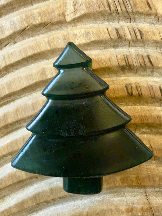 Deep green chamomile soap shaped like a Christmas tree with natural speckling and translucent finish.