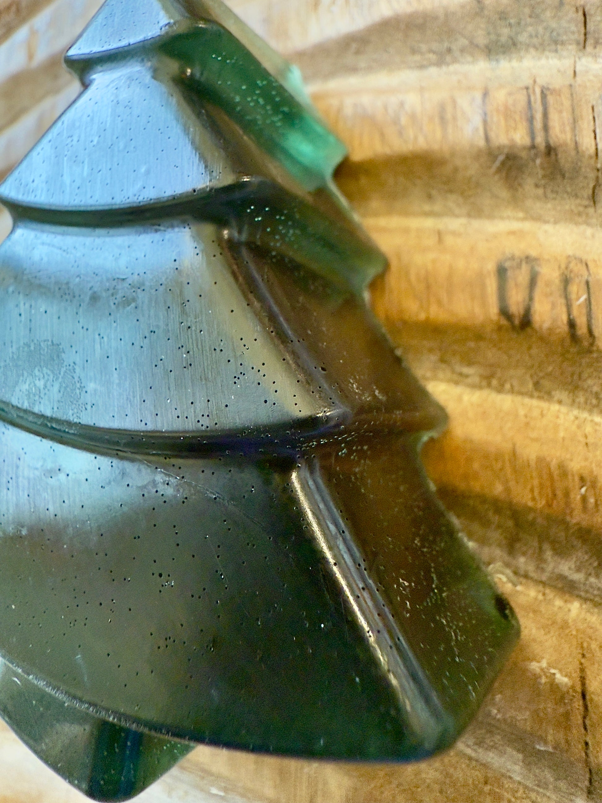 Deep green chamomile soap shaped like a Christmas tree with natural speckling and translucent finish.