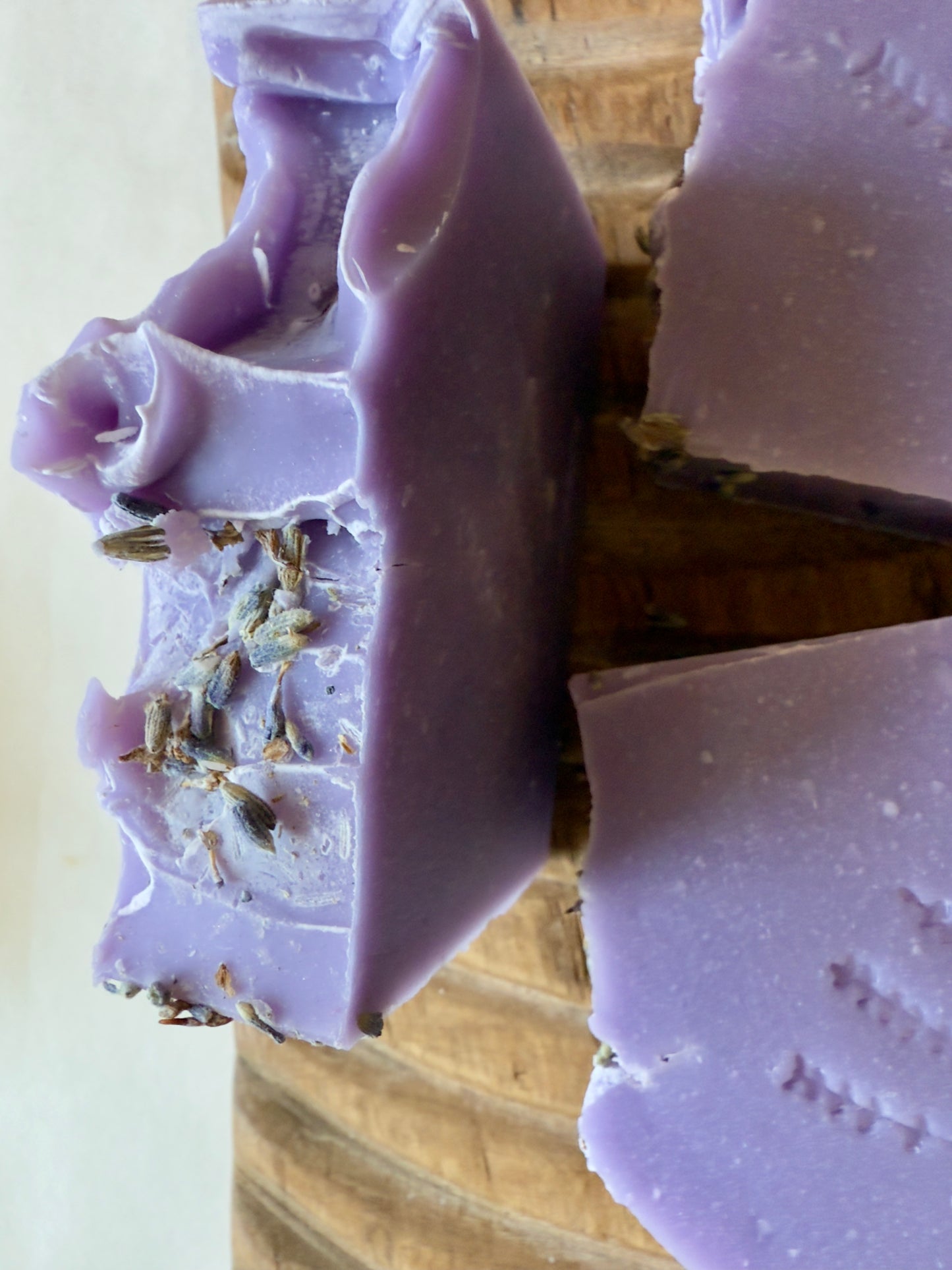 Lavender CP soap bars with a stamped lavender sprig design on a wood board.