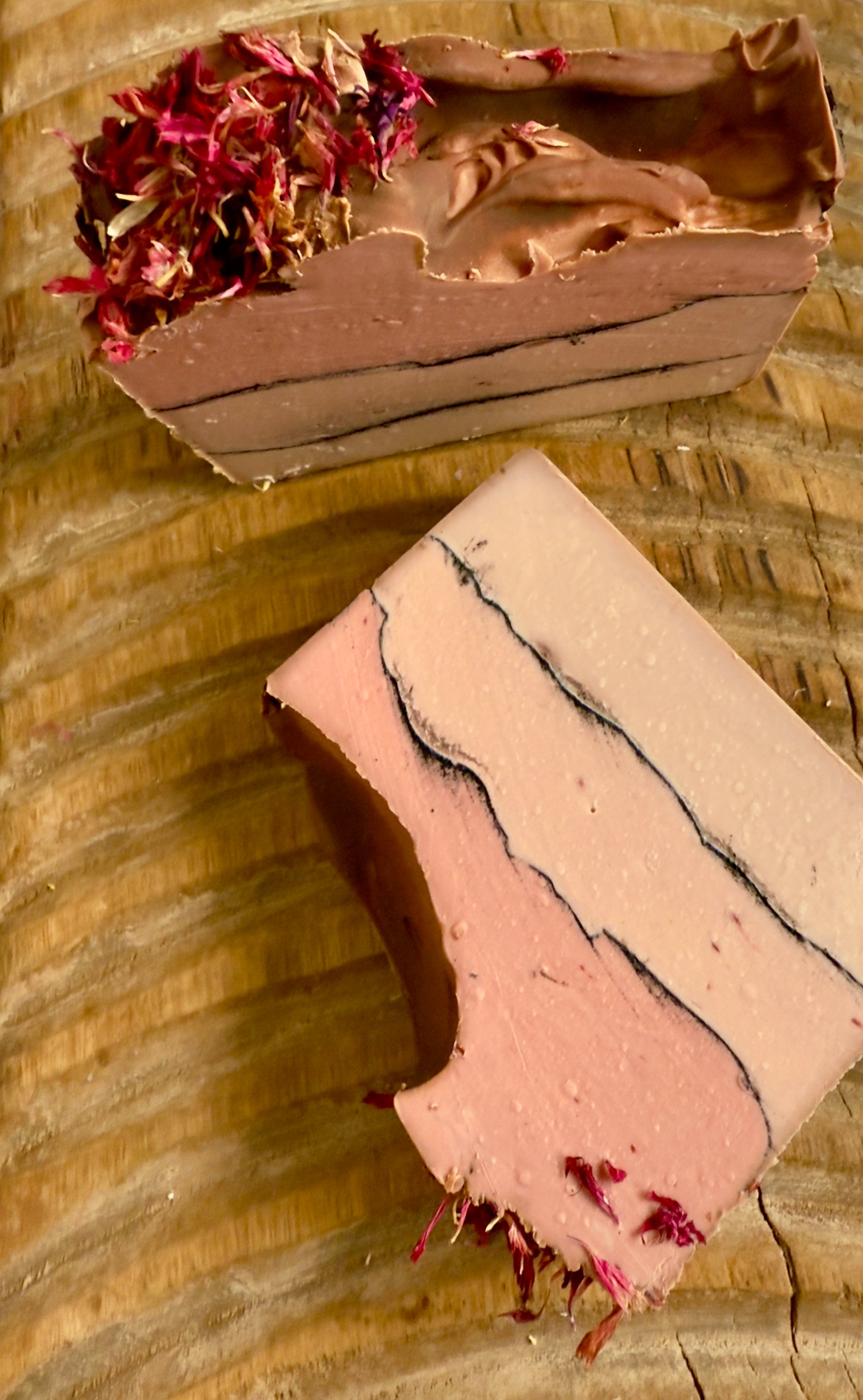 Layered rose and cream soap bar with charcoal line and pink cornflower topping