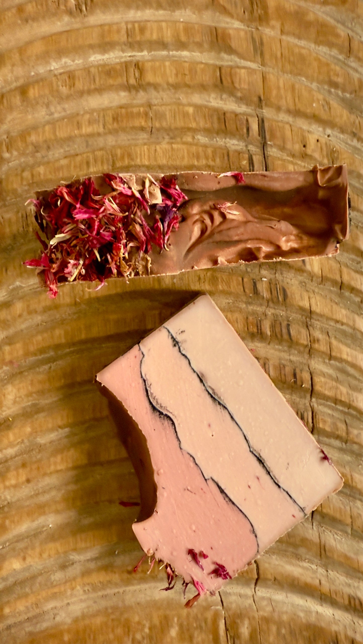Layered rose and cream soap bar with charcoal line and pink cornflower topping