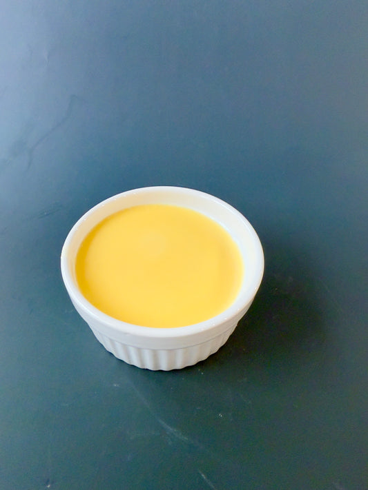“Orange solid dish soap poured into white ceramic ramekin”