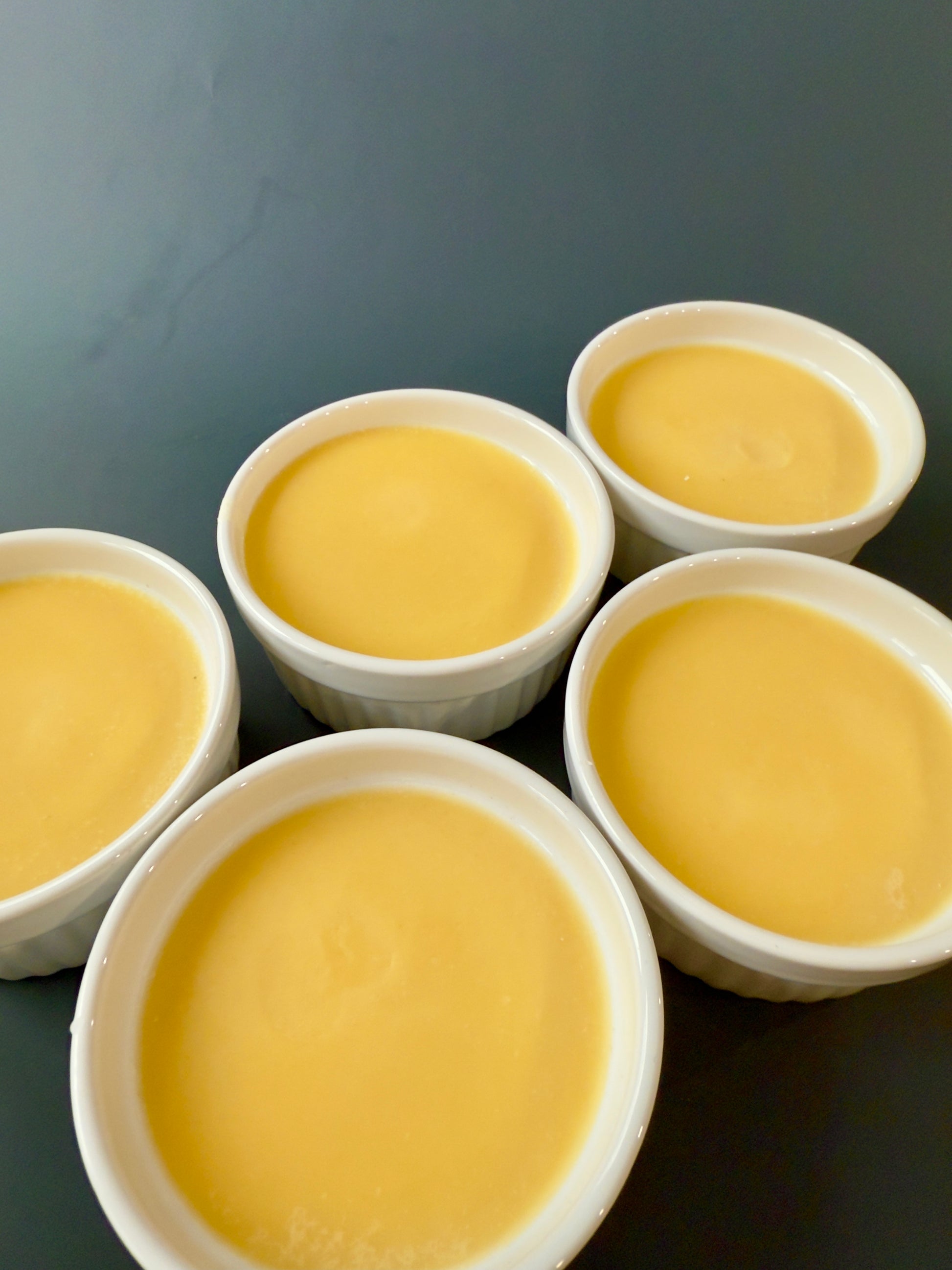 Orange solid dish soap poured into five small white ramekins