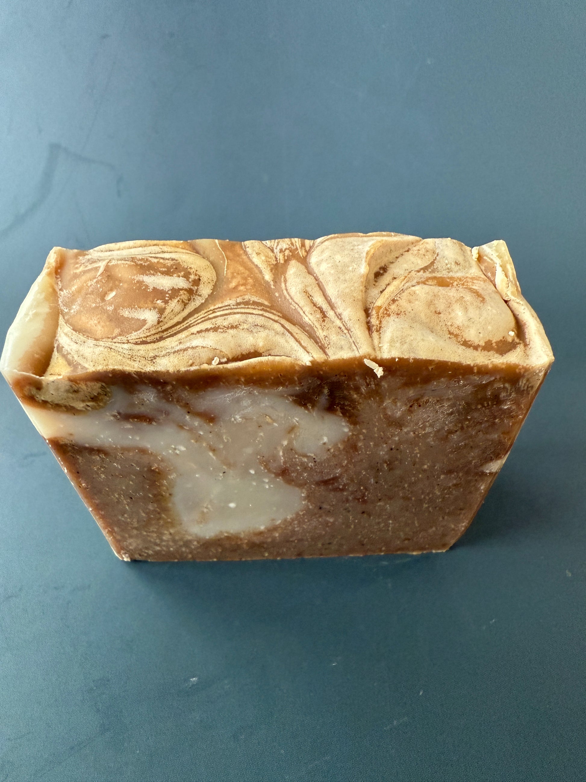 Marbled brown and beige soap bar on a dark gray background