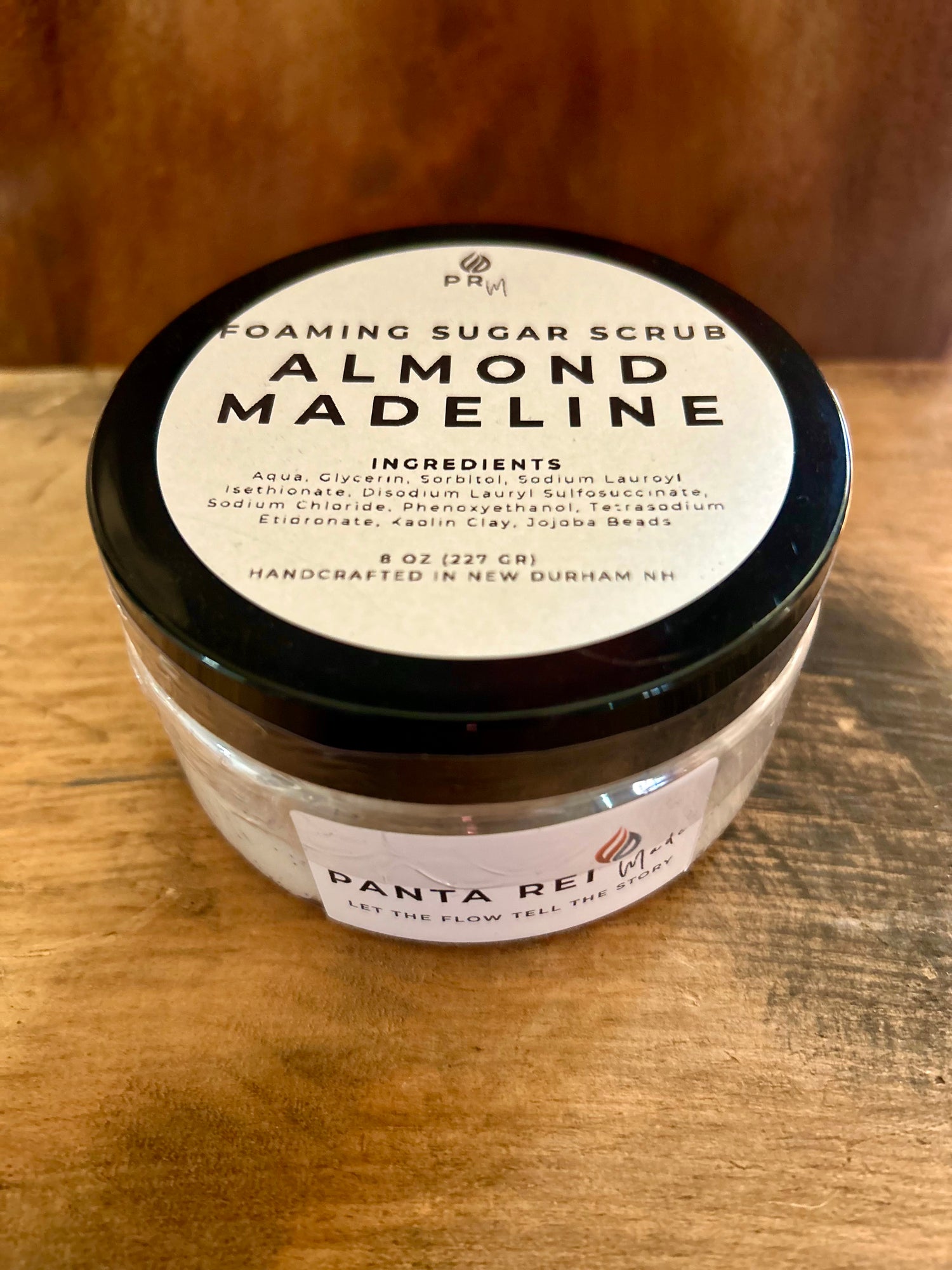 Jar of Panta Rei Almond Madeleine Foaming Sugar Scrub on a wooden surface