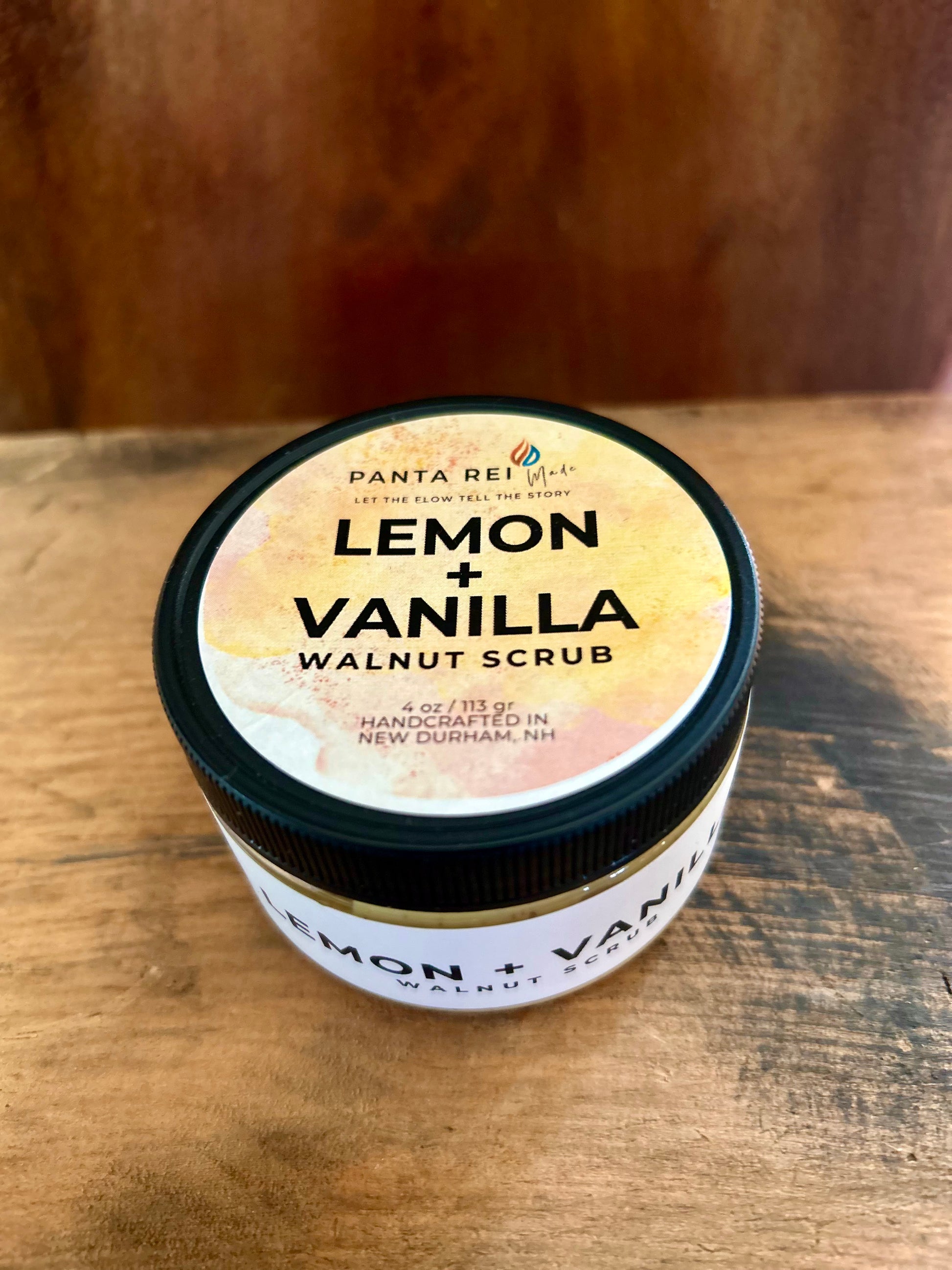 Jar of lemon and vanilla walnut scrub on a wooden surface