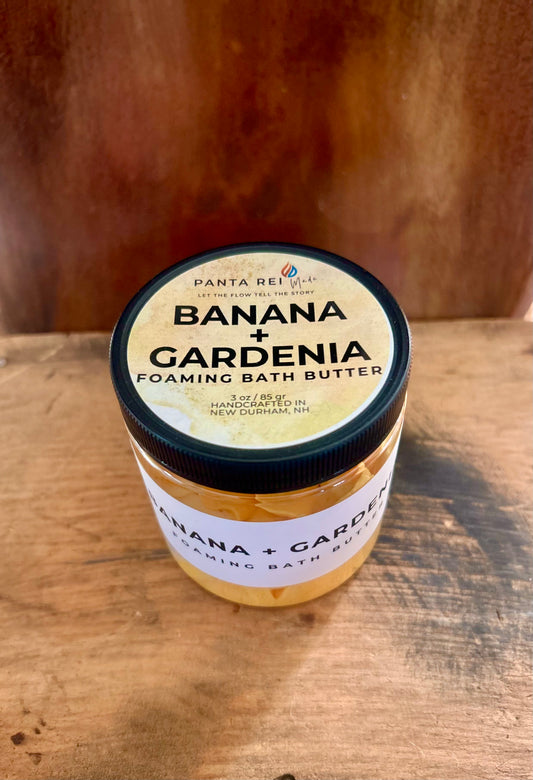 “Banana + Gardenia Soap Soufflé in a clear jar with white and yellow whipped swirls.”