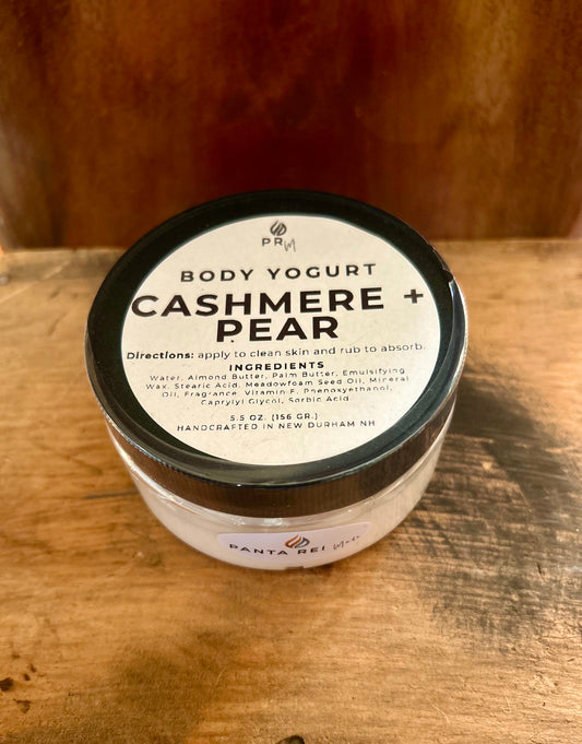 Jar of Cashmere + Pear Body Yogurt with black lid on a wooden surface, labeled Panta Rei Made.