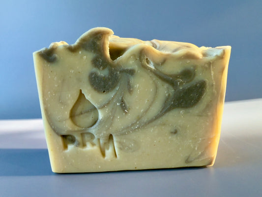 Soap bar with warm brown and cream marbling and PRM logo on blue background