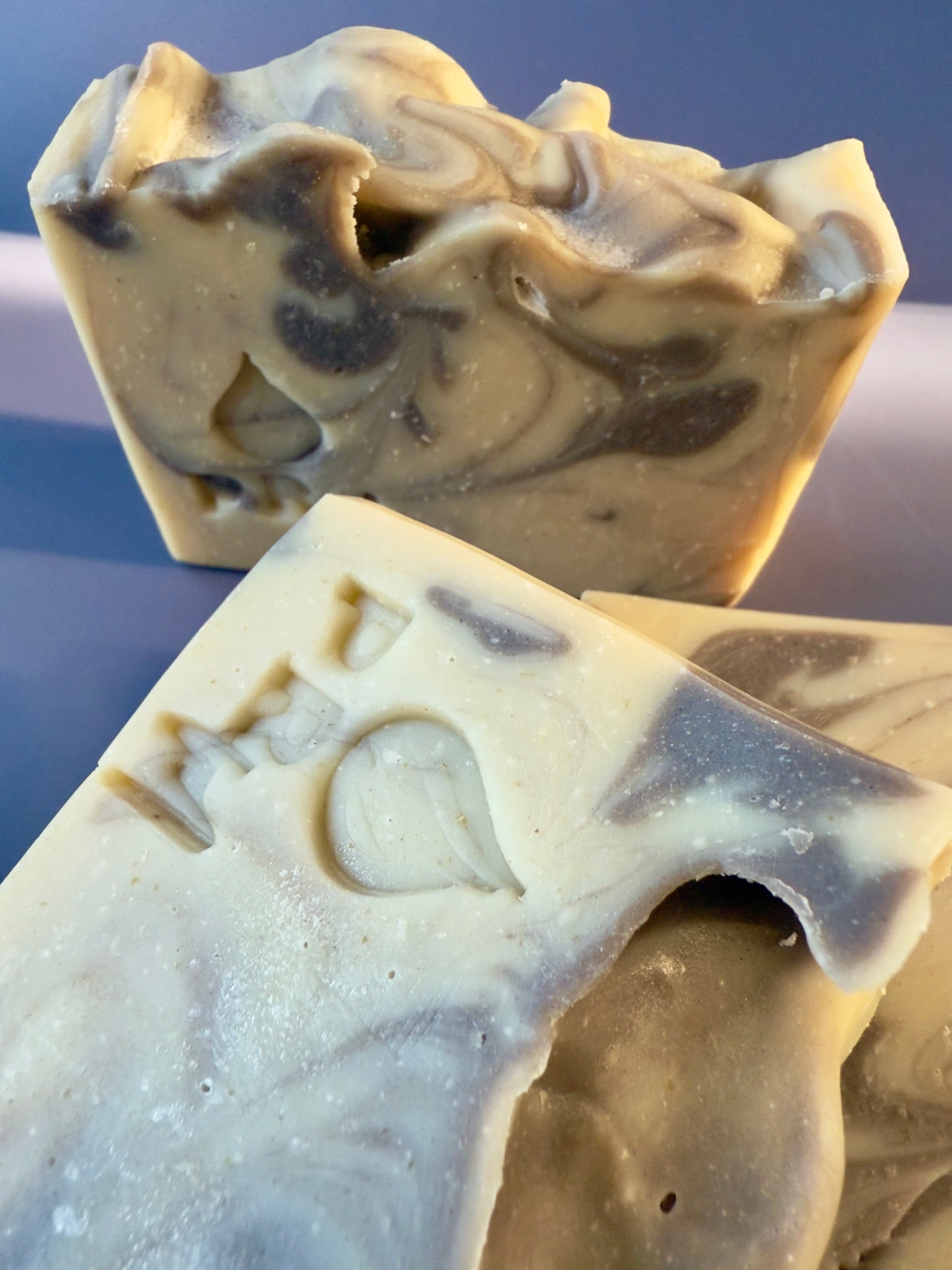 Two bars of soap with a marbled pattern on a neutral background
