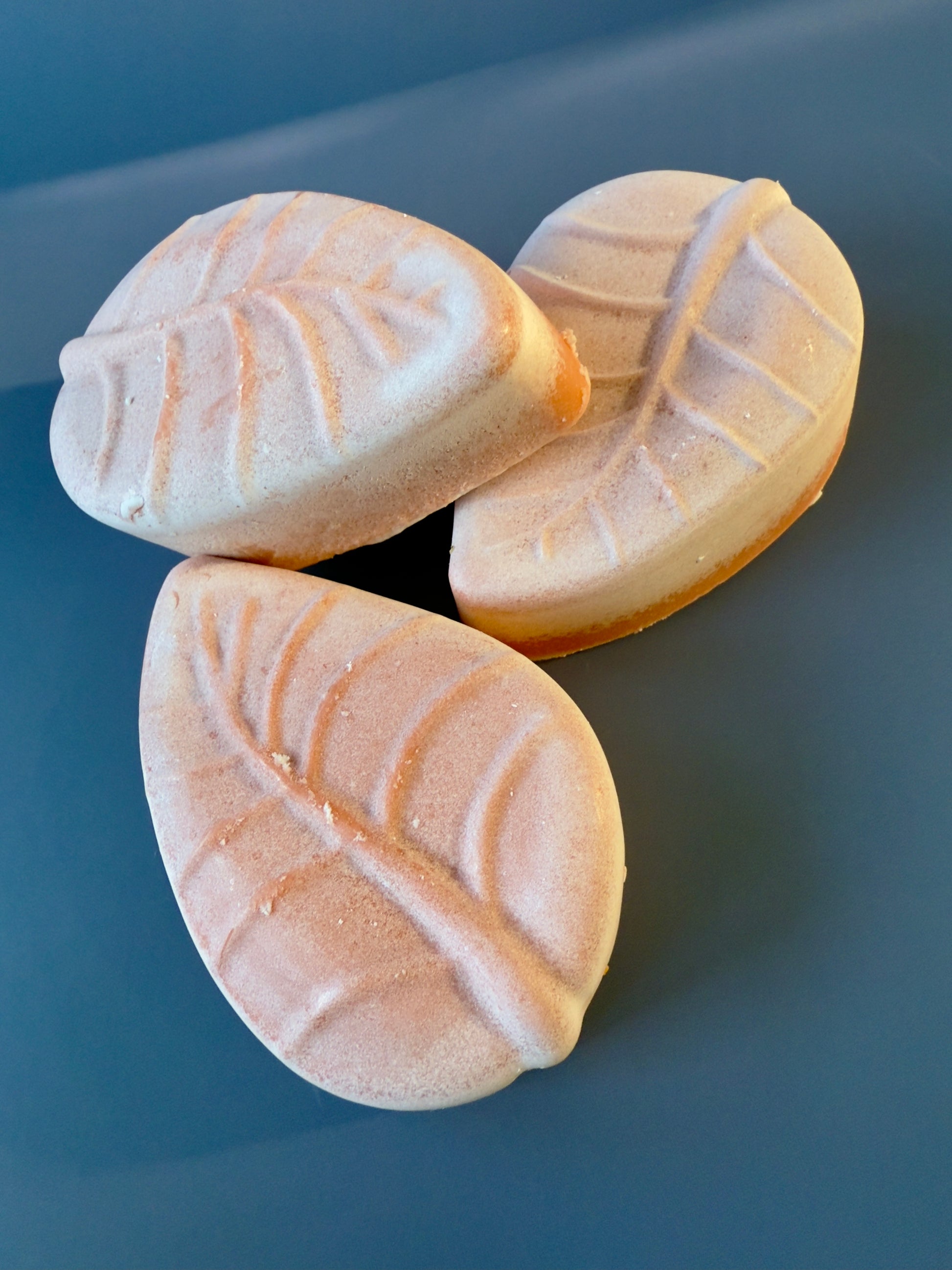 Three leaf-shaped soaps arranged together, highlighting molded vein detail