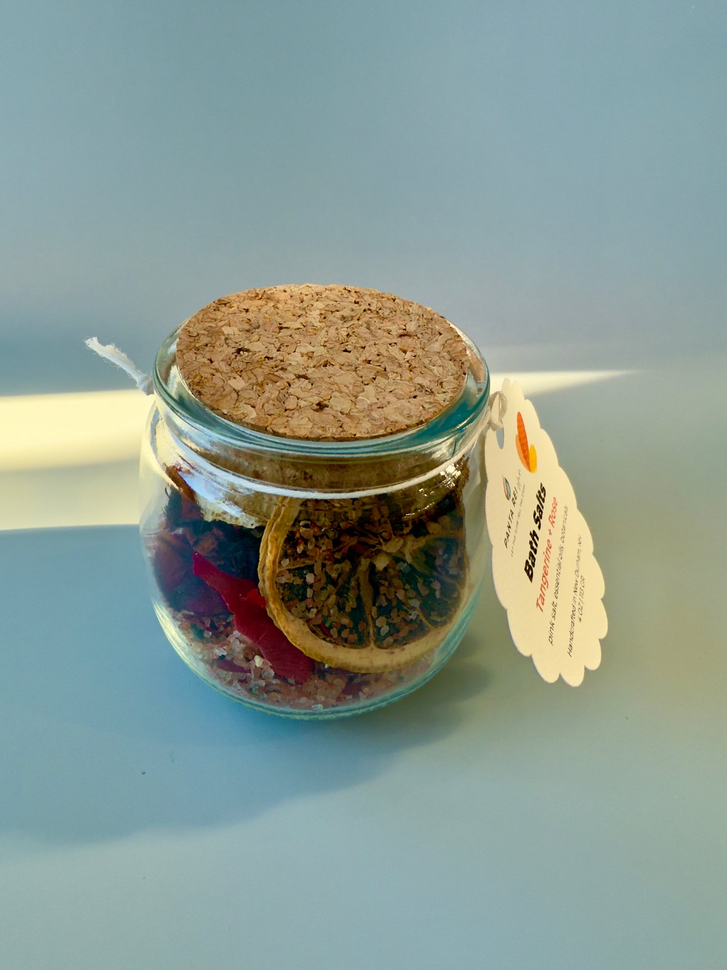 Side view of Tangerine + Rose bath salts jar showing botanical layers and cork top.