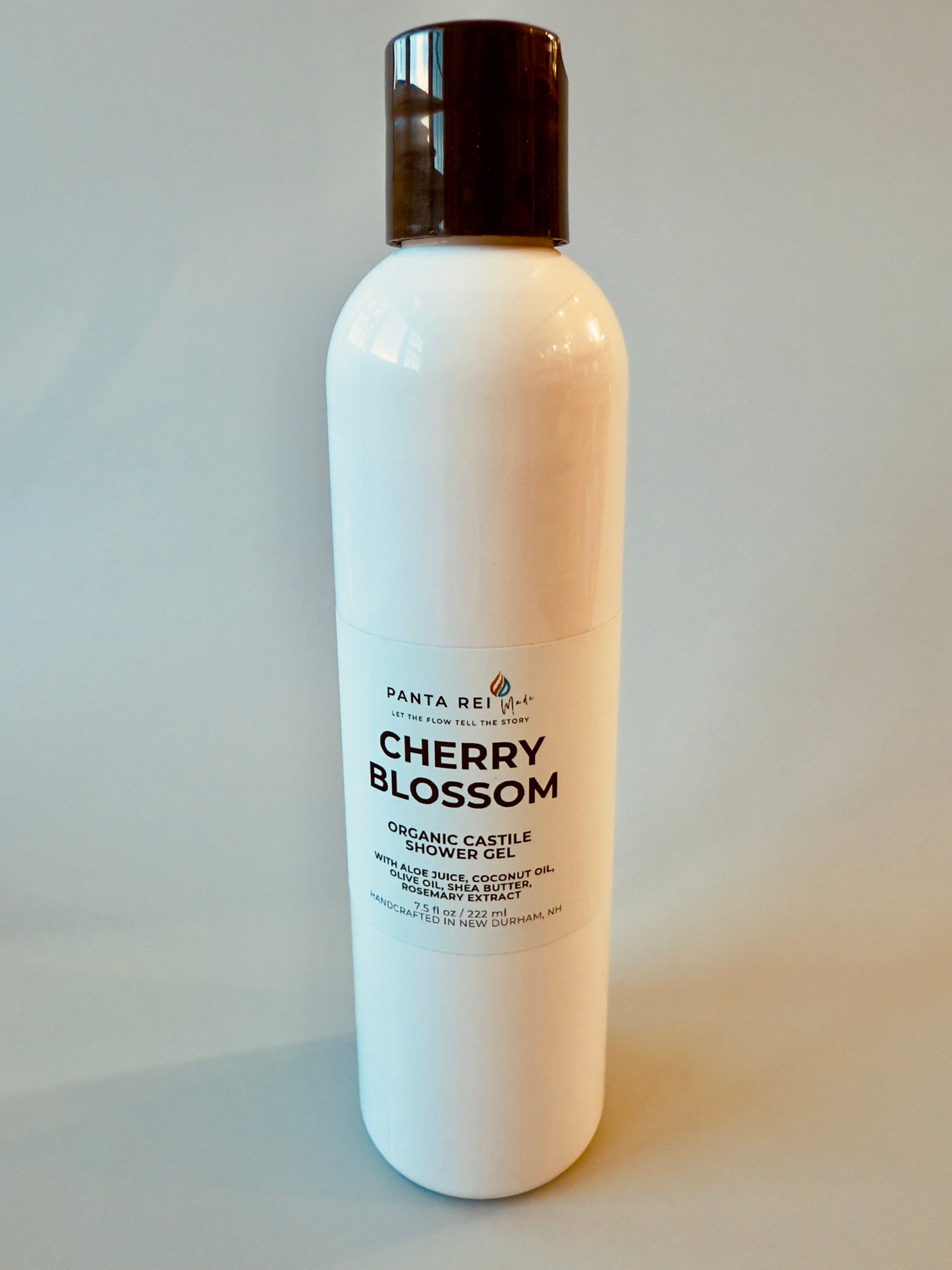 White bottle with black cap labeled Cherry Blossom Organic Castile Shower Gel.