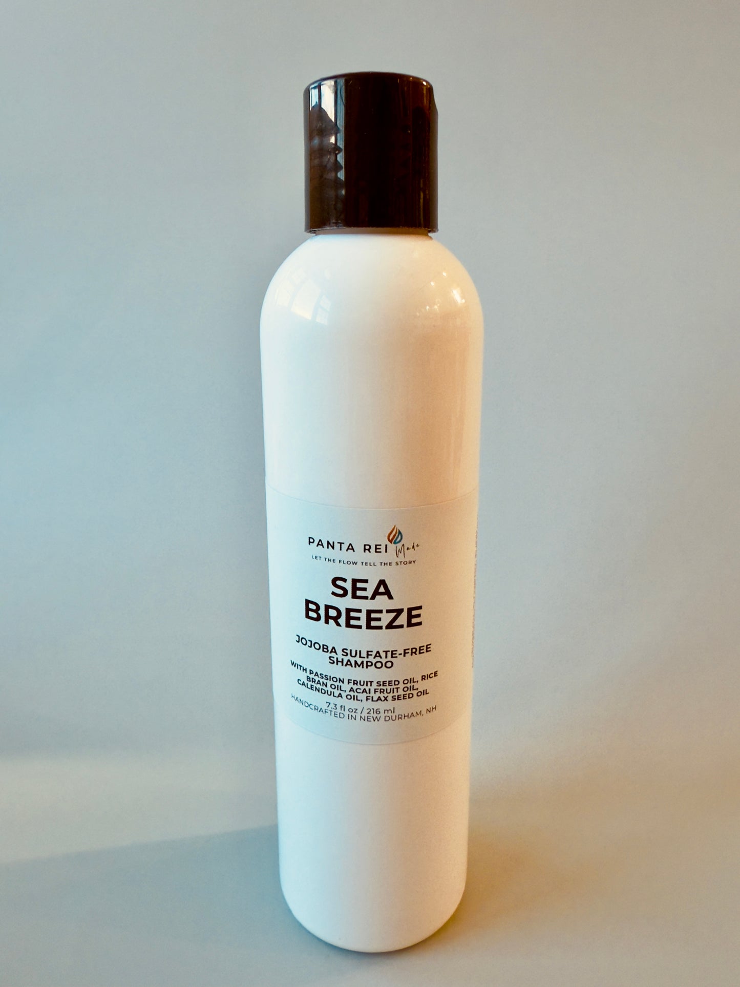 White bottle with black cap labeled Sea Breeze sulfate-free shampoo.