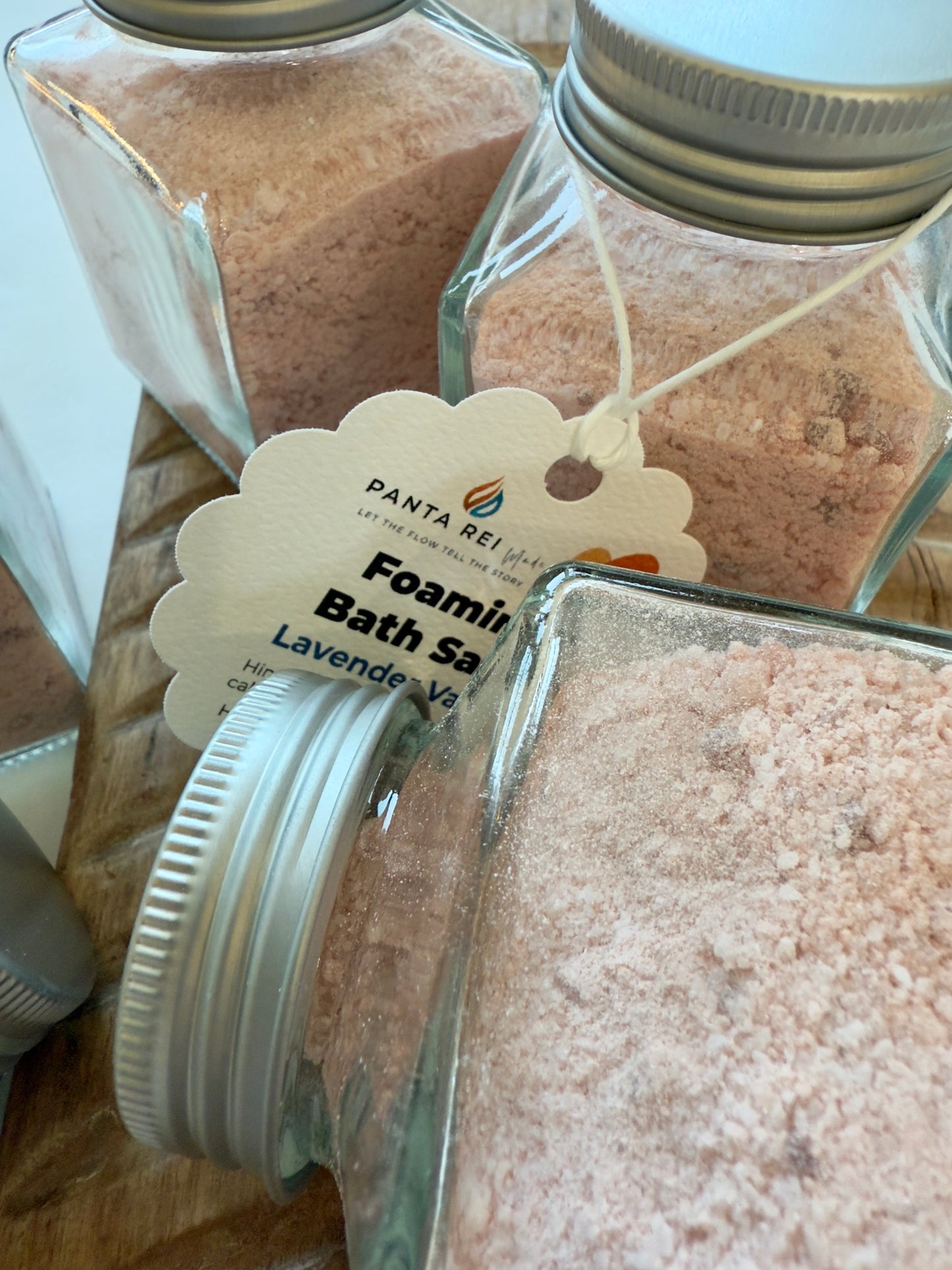 Group of Lavender Vanilla foaming bath salt jars showing soft pink powder and metal lids.