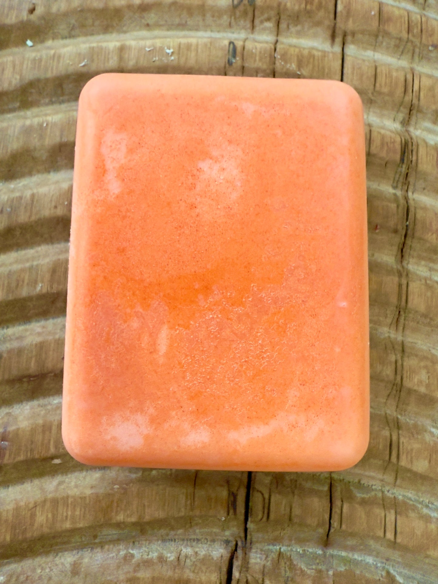 Orange rectangular shampoo bar with soft marbled texture.