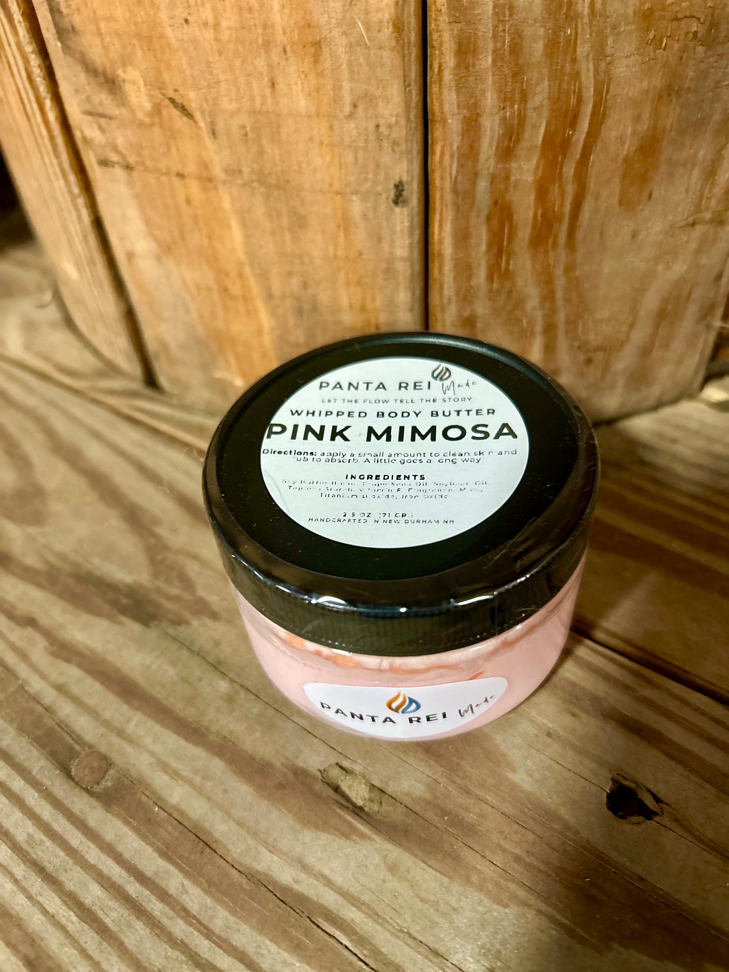 “Pink Mimosa whipped body butter in clear jar with black lid, handcrafted by Panta Rei Made.”