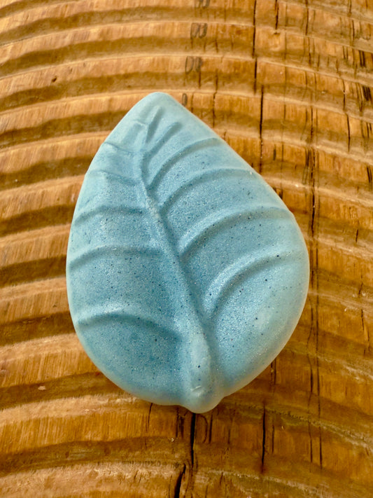 Leaf-shaped chamomile lavender shampoo bar in stormy blue with subtle shimmer.