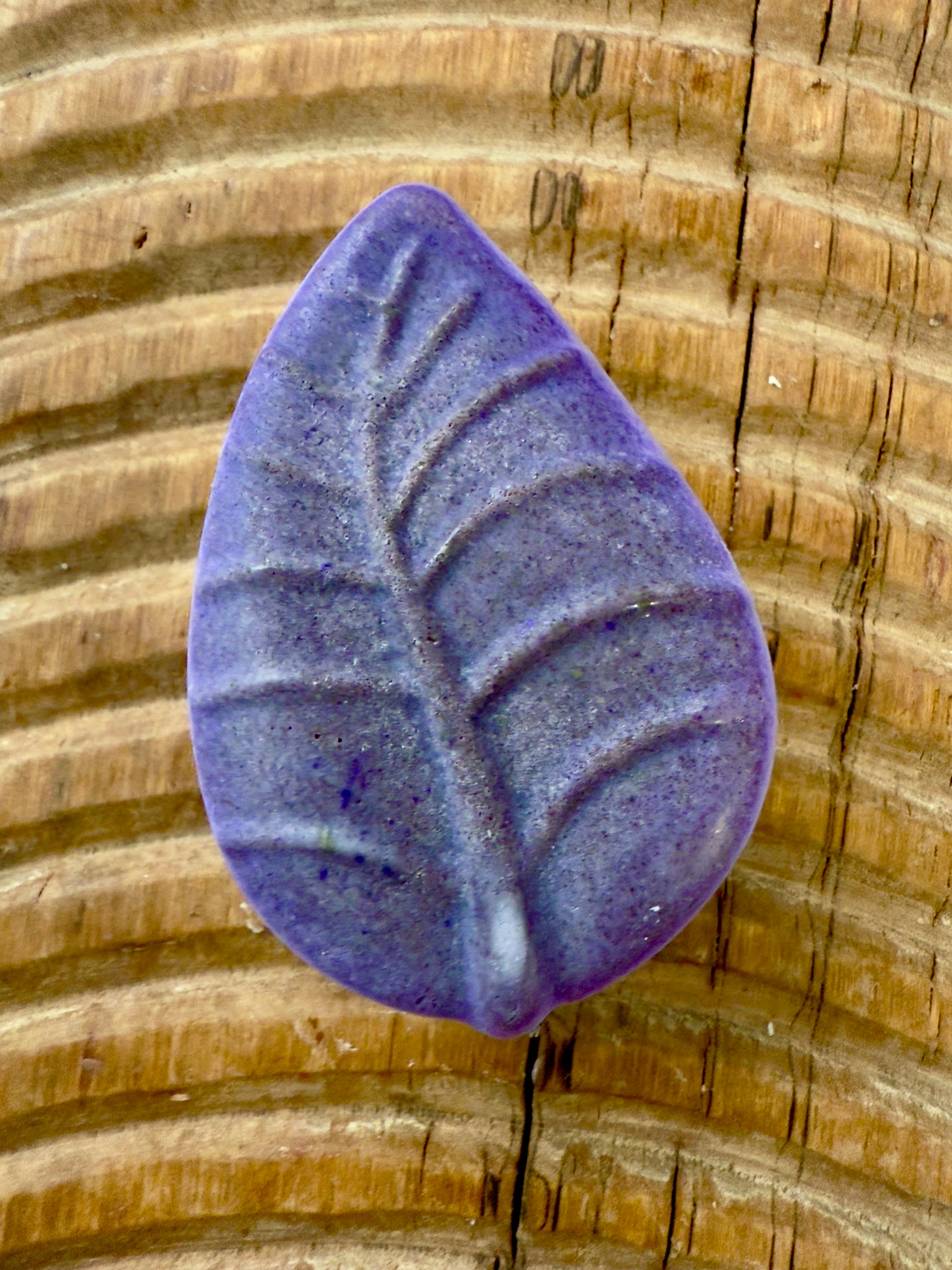 Purple leaf-shaped rosemary and lavender solid shampoo bar with natural speckling.
