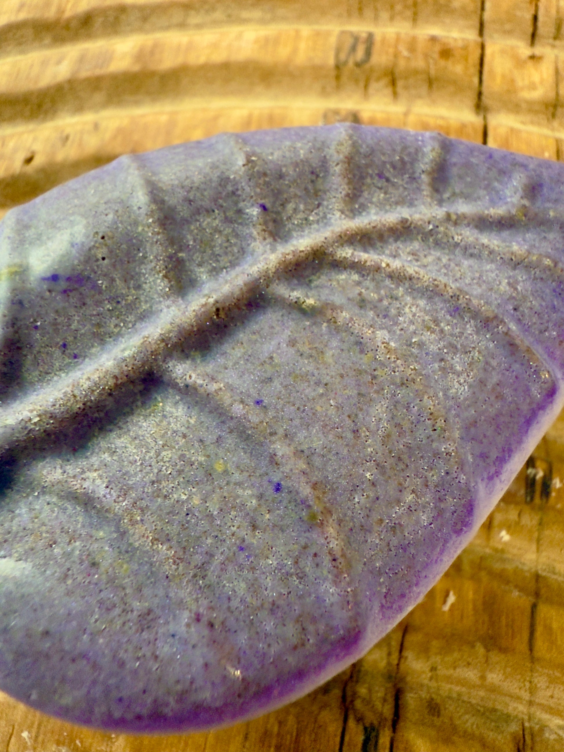 Purple leaf-shaped rosemary and lavender solid shampoo bar with natural speckling.