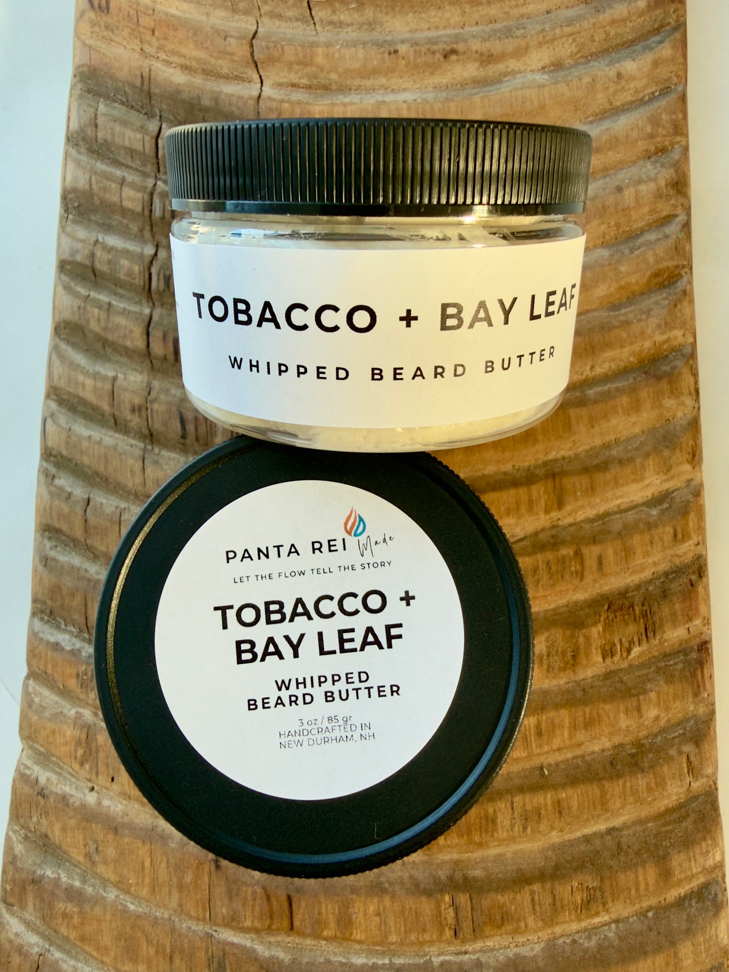 Tobacco + Bay Leaf whipped beard butter jar on carved wood background.