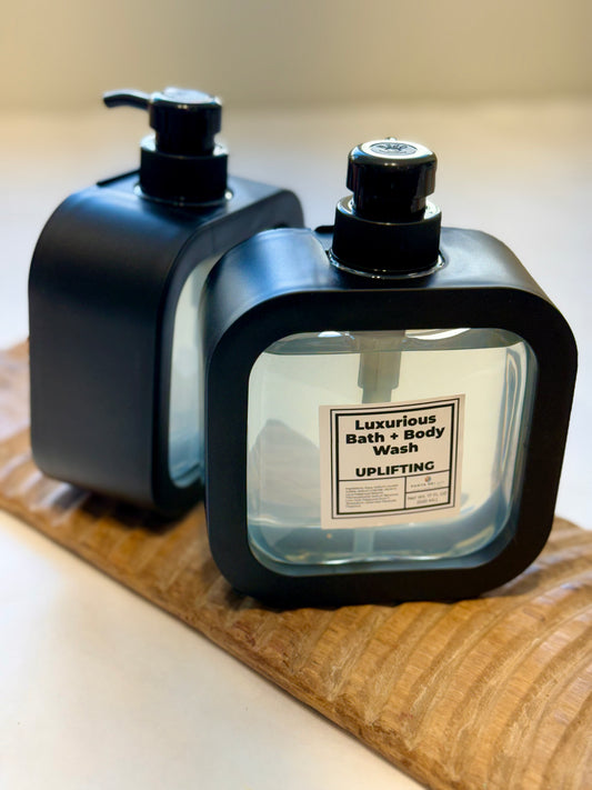 Pair of Uplifting Bath + Body Wash bottles displayed on wood board