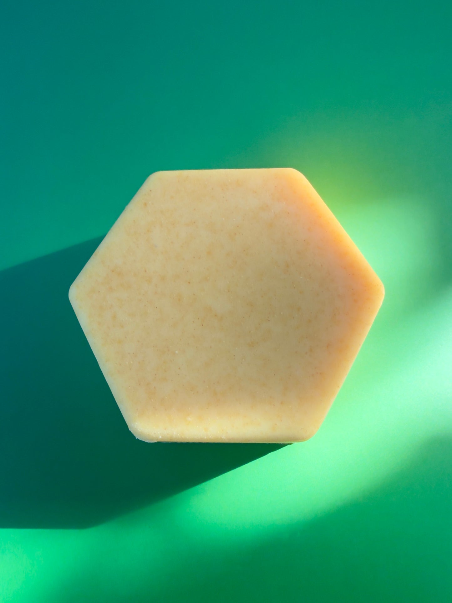 Hexagon-shaped citrus soap with pale yellow tone and fine natural speckling