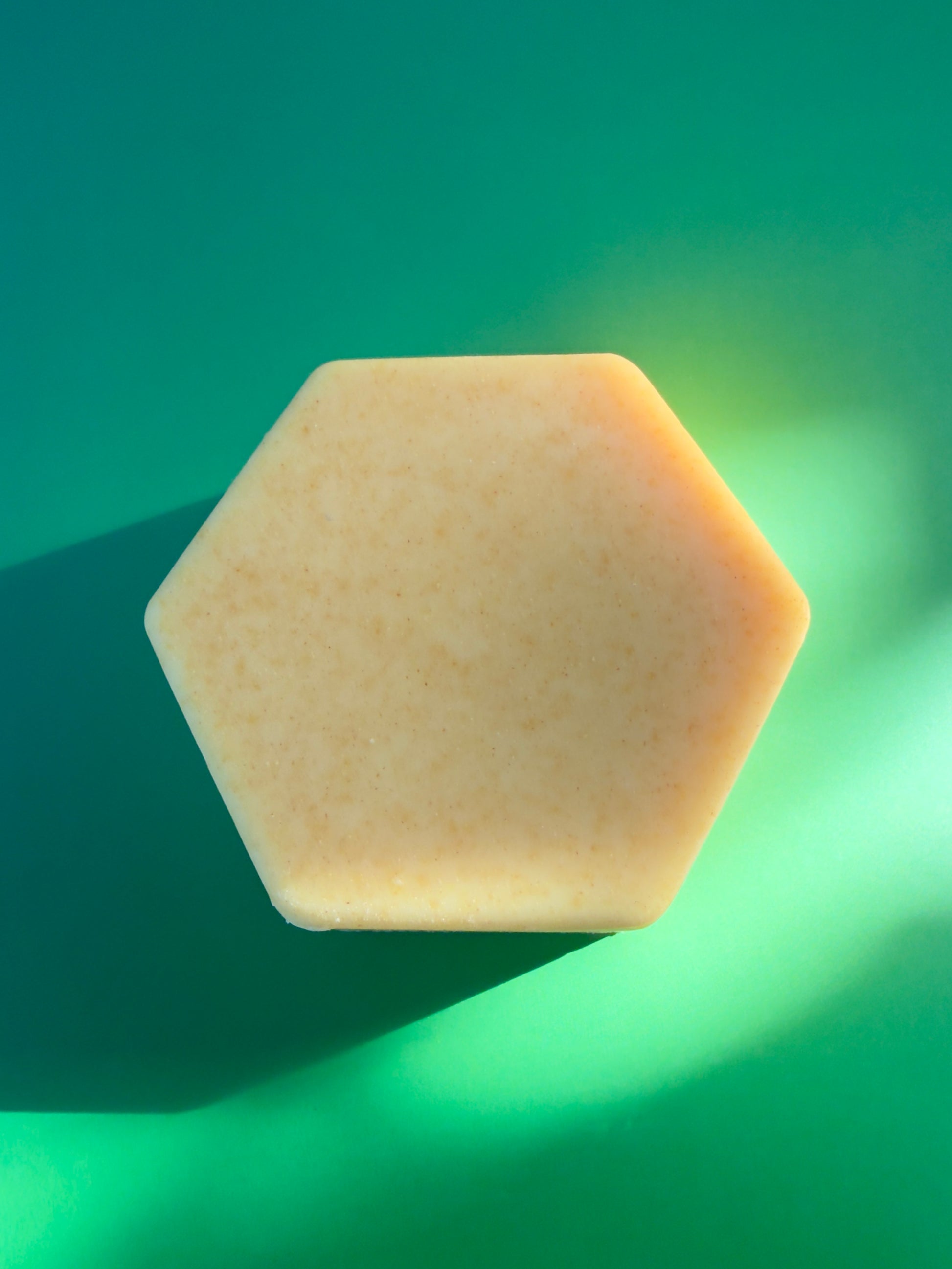 Hexagon-shaped citrus soap with pale yellow tone and fine natural speckling
