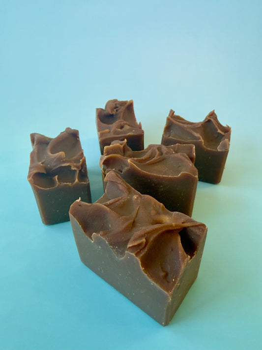 Group of small soap chunks arranged loosely, warm brown tones visible