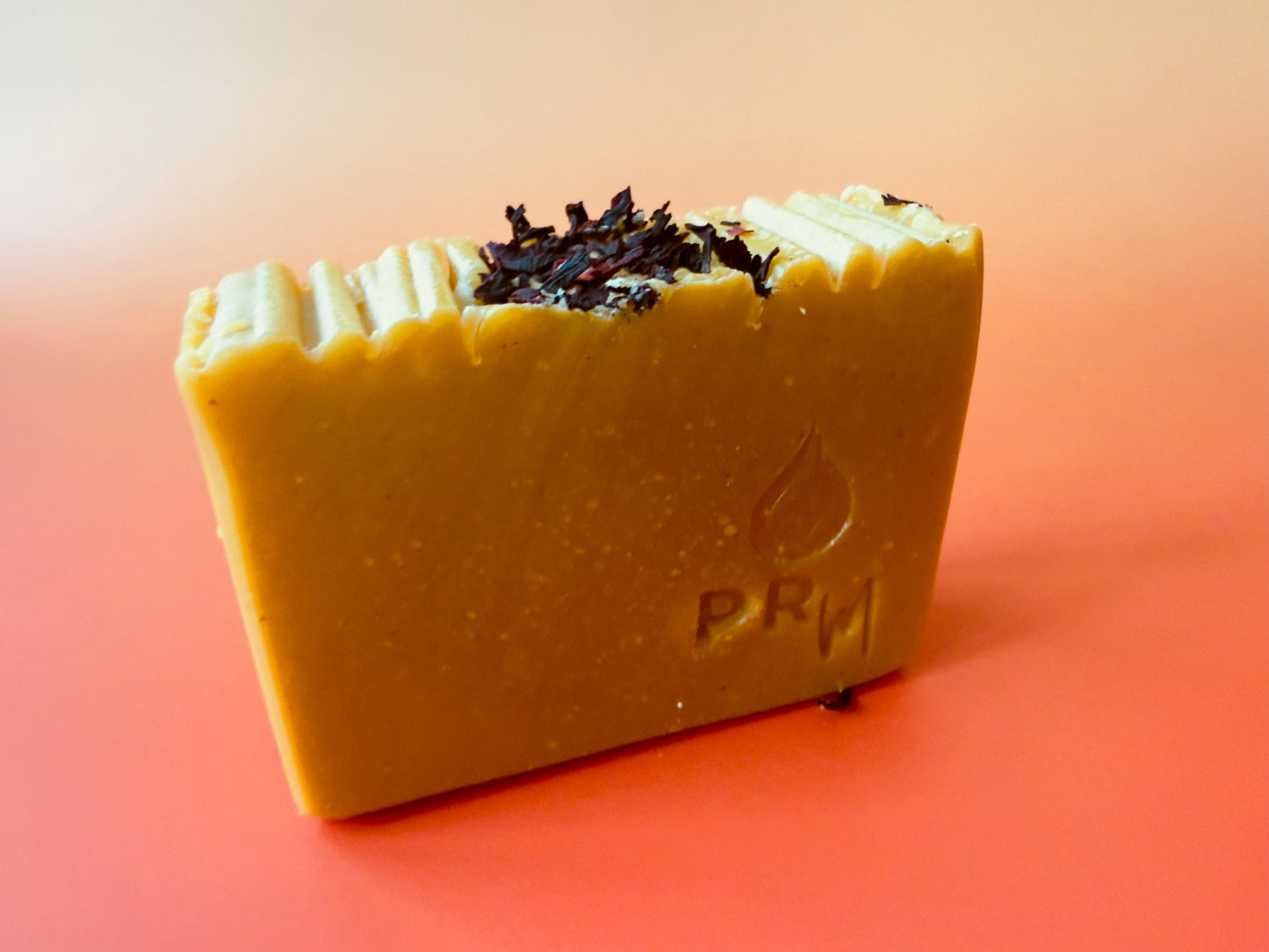 Apple Wisteria soap bar on gradient background, ridged top with small botanical accent