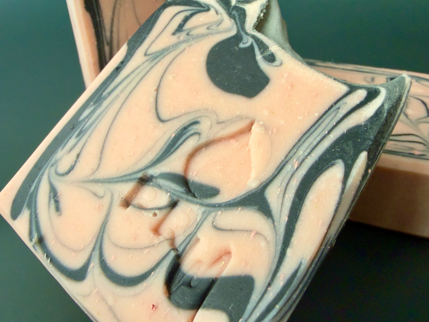 Close-up of group of soap showing smooth swirls and layered tones in pink and black