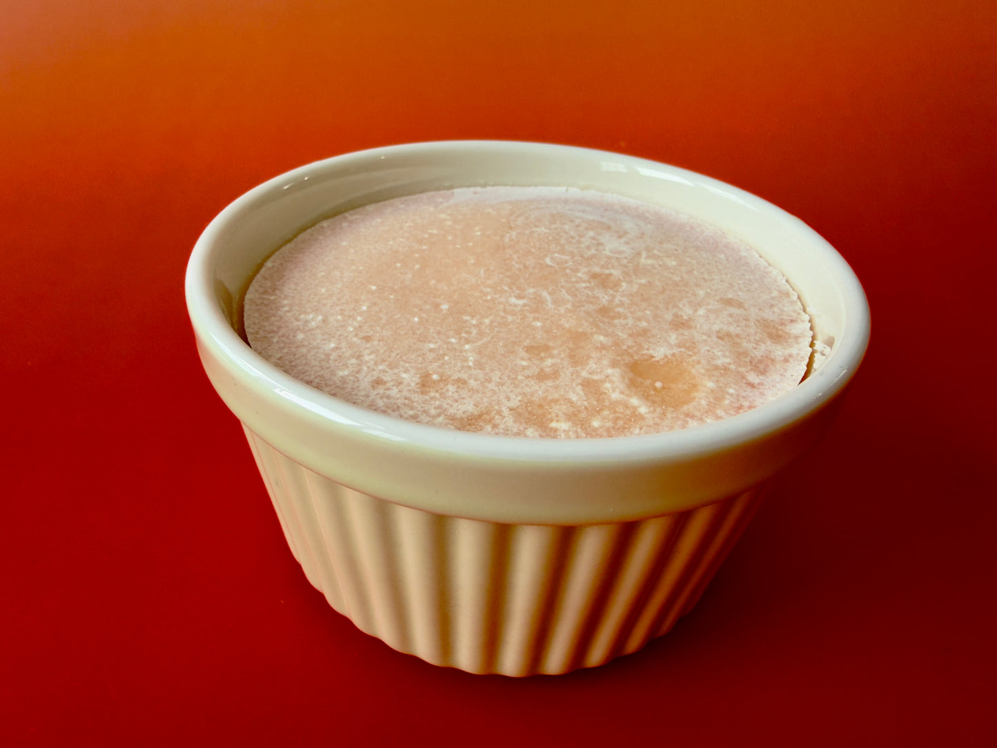 Side view of ribbed ceramic ramekin filled with solid kitchen soap