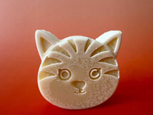 Unscented baby soap shaped like a cat face with soft cream tones