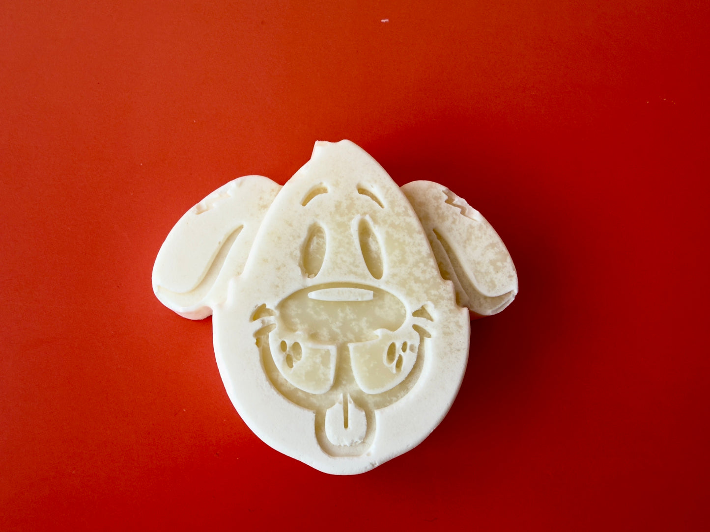 Fragrance-free baby soap molded as a puppy face on a warm background