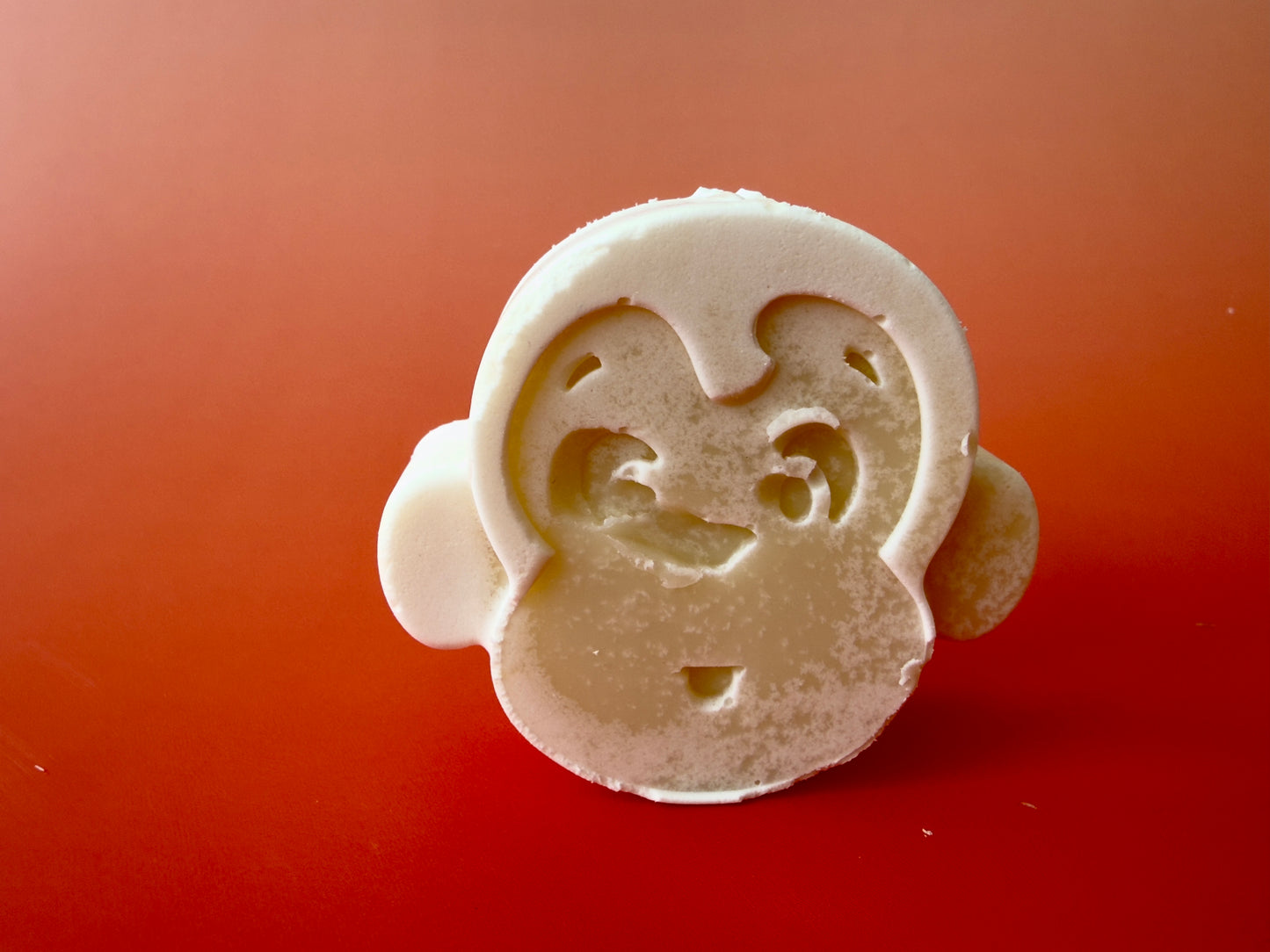 Baby soap shaped like a monkey face with smooth, rounded contours