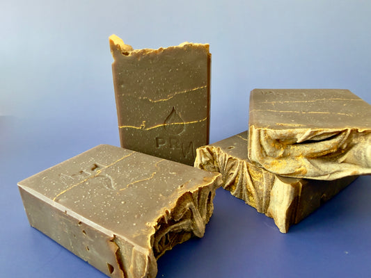 Group of almond sandalwood soap bars showing layered interiors and textured tops