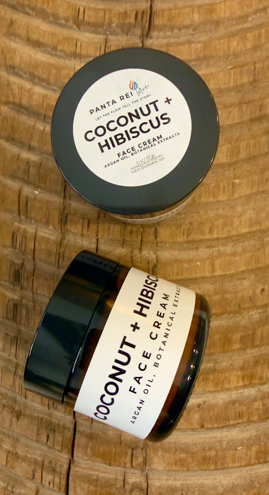 Face cream in amber glass jar with minimalist Panta Rei Made label on wood surface (coconut + hibiscus)