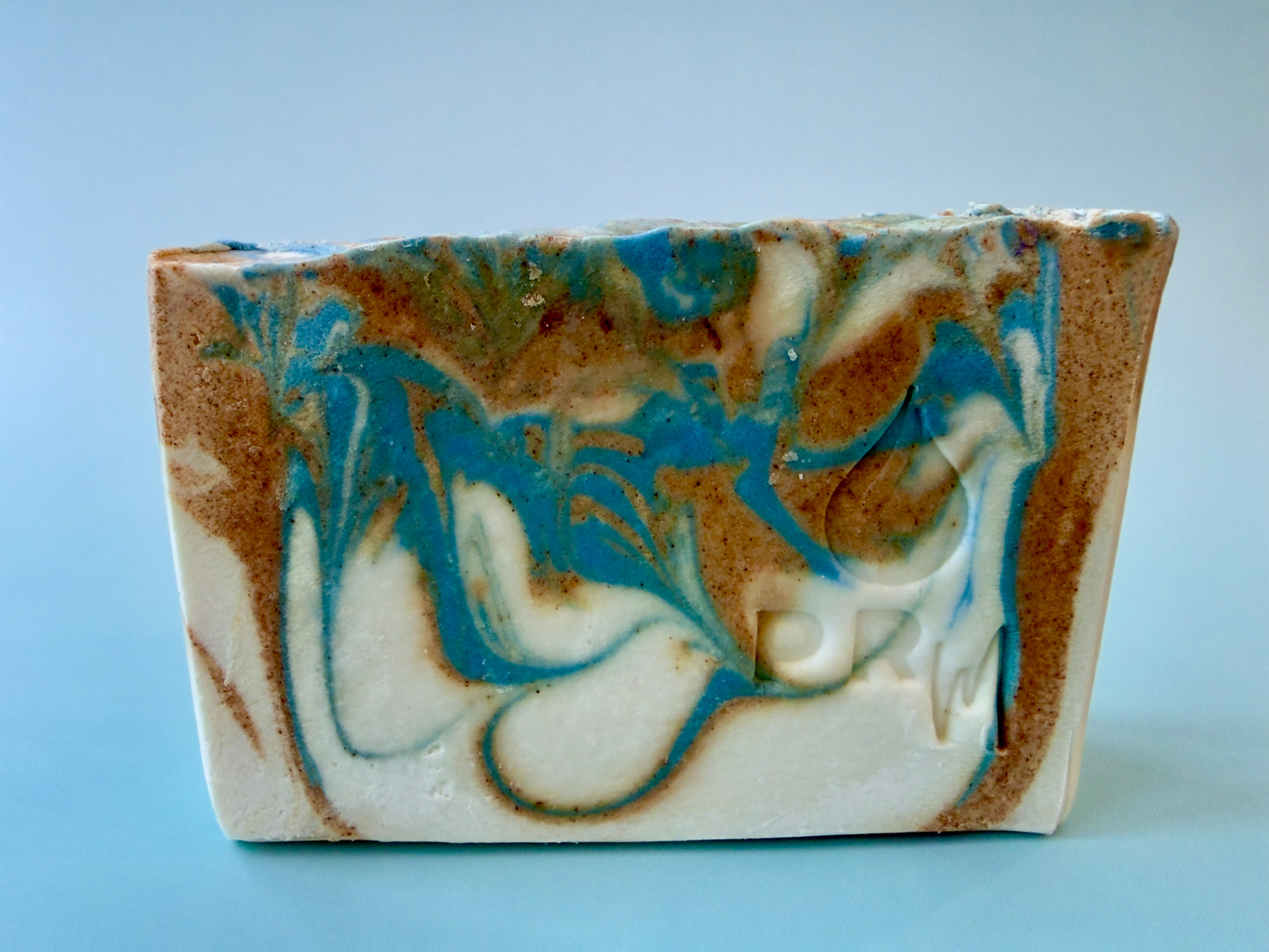 Citrus + Jasmine small batch soap with blue, cream, and warm turmeric-toned swirl.