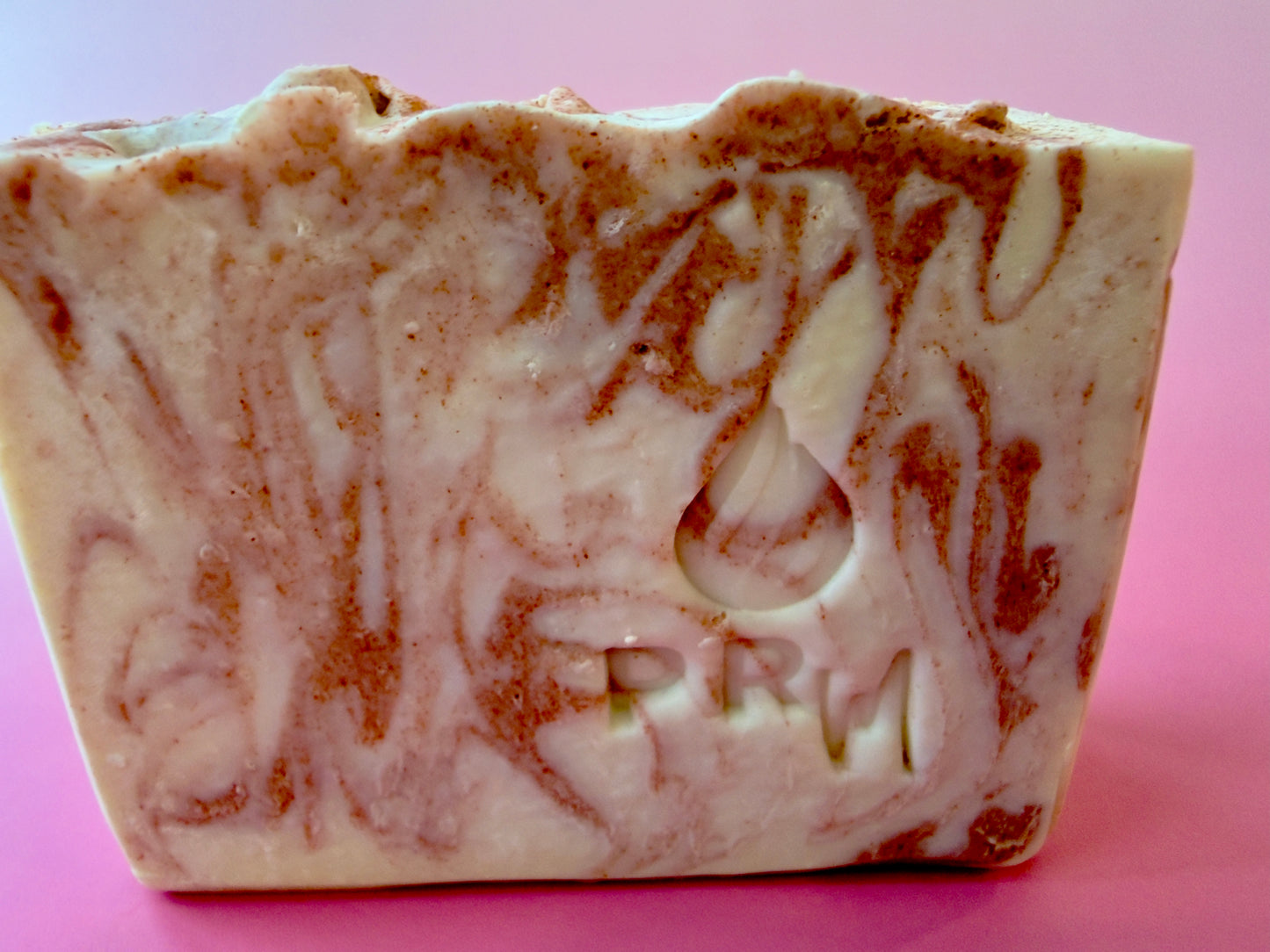 Close-up of Sweet Bergamot aloe soap showing PRM stamp and copper-toned swirl.